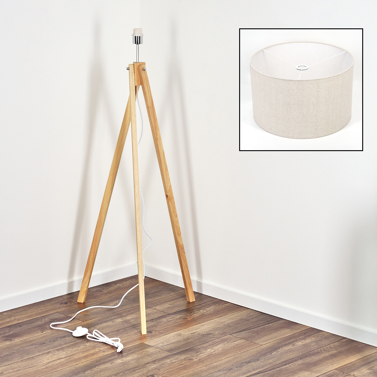Eine hölzerne Stativlampe mit beigem Lampenschirm, weißem Kabel und zusätzlichem Lampenschirm.