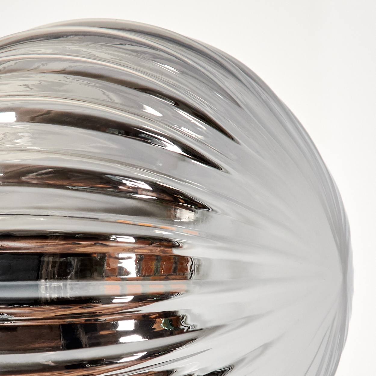 Nahaufnahme einer metallischen, silbernen, strukturierten Kugel mit reflektierender Oberfläche.