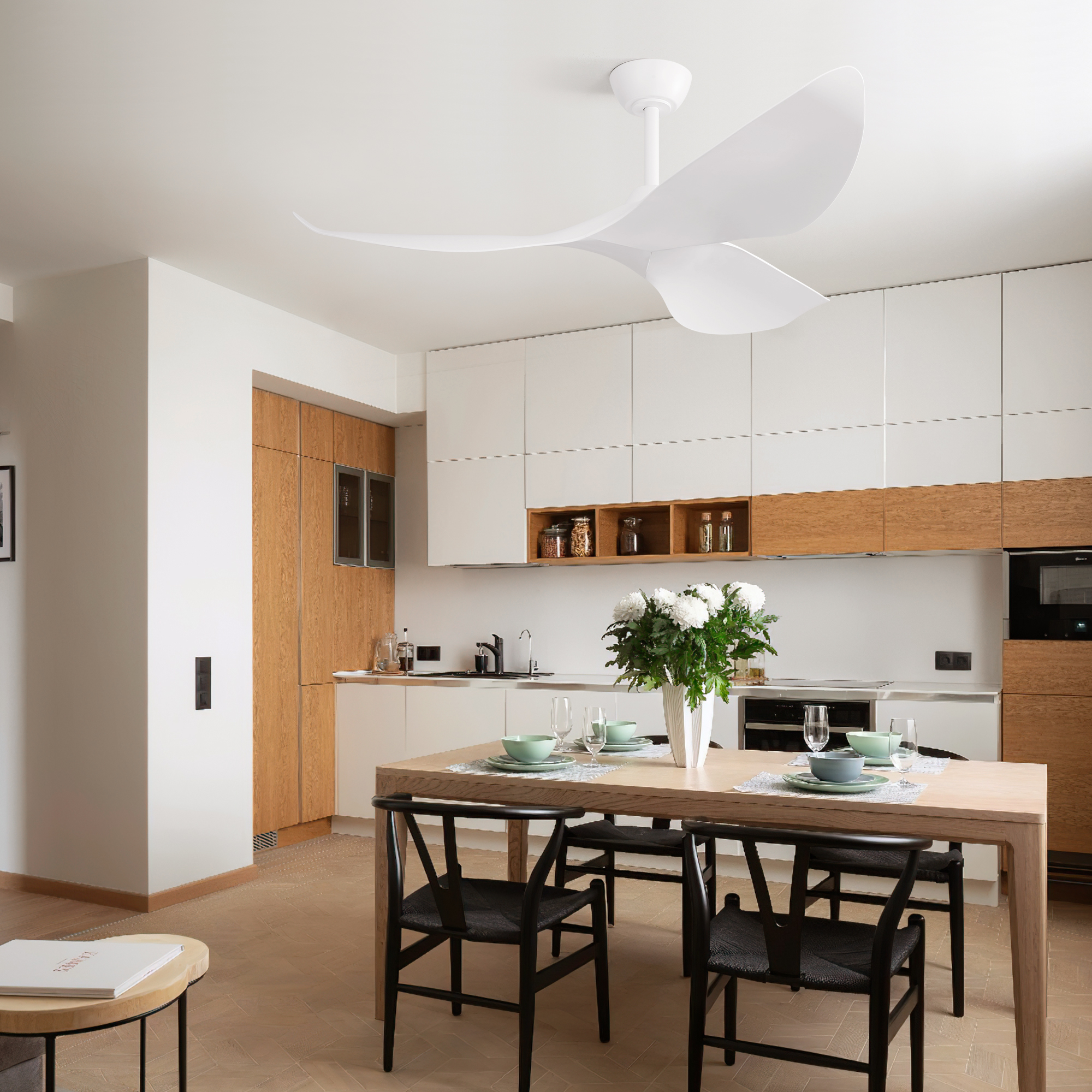 Eine Küche mit weißem Deckenventilator, Holzschränken und einem Esstisch mit Stühlen.