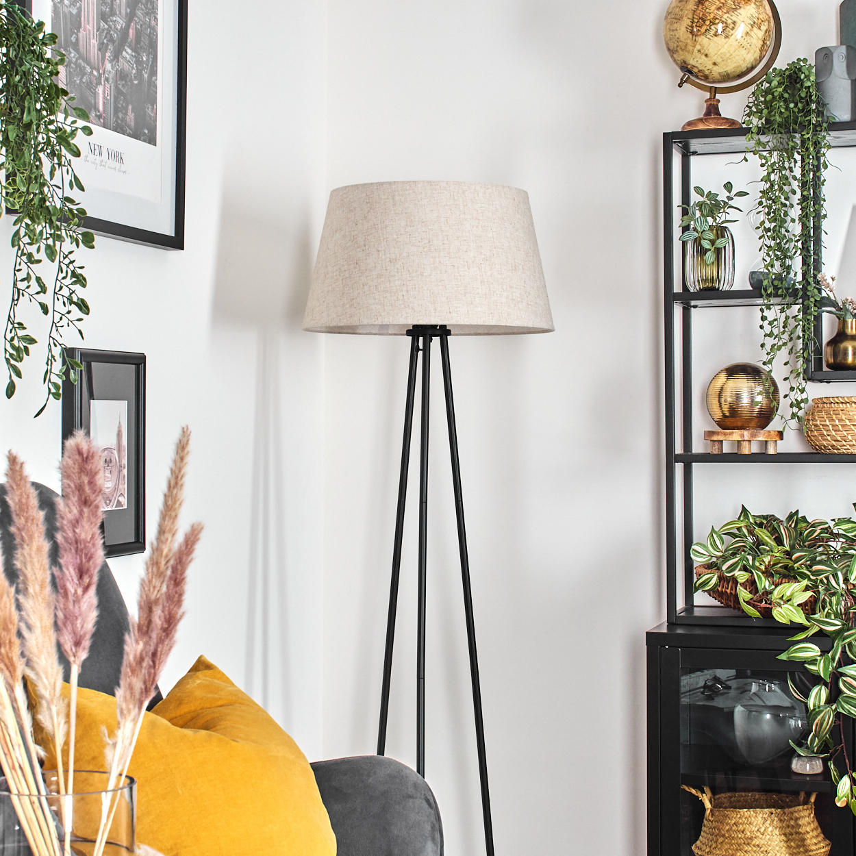 Zimmerecke mit Stehlampe mit beigem Lampenschirm und schwarzem Rahmen.