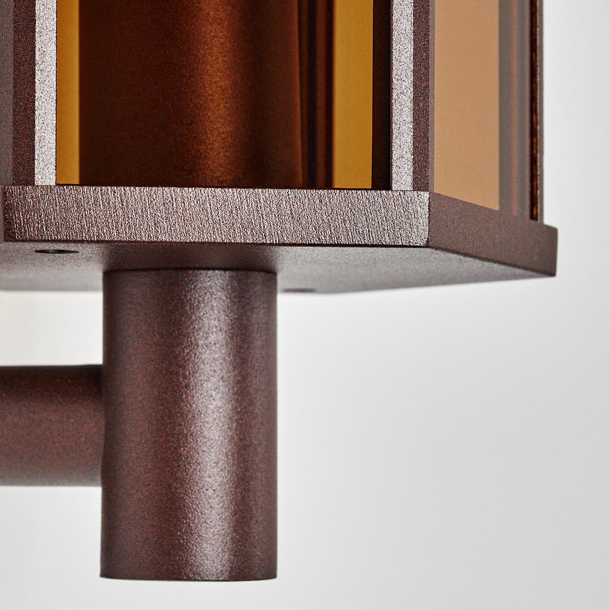Nahaufnahme einer bronze-farbenen Außenleuchte. Sie hat geometrische Glasscheiben.