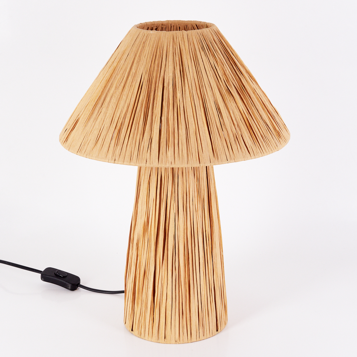 Tischlampe mit pilzförmigem Lampenschirm aus Bast. Die Lampe steht auf weißem Hintergrund.