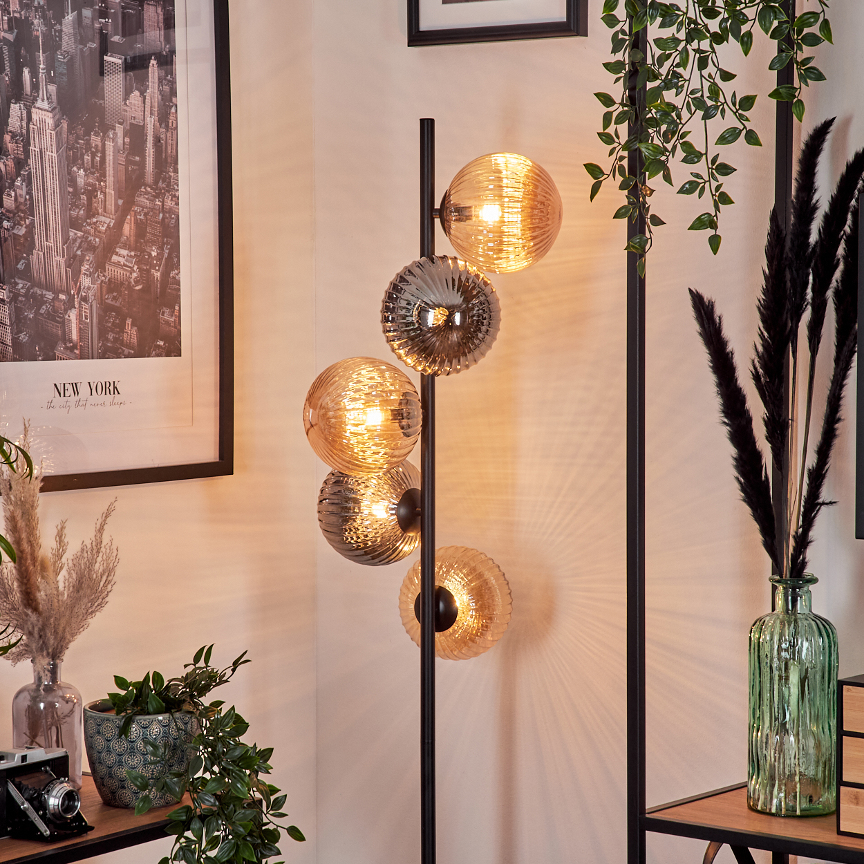 Stehlampe mit schwarzem Stab und mehreren kugelförmigen Glasschirmen in Gold und Silber.