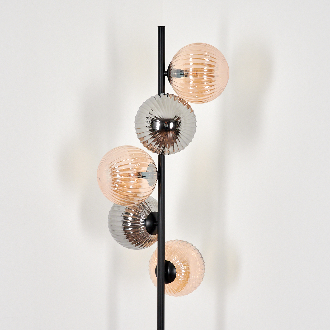 Stehlampe mit schwarzem Stab und mehreren kugelförmigen Glasschirmen in Silber und Orange.