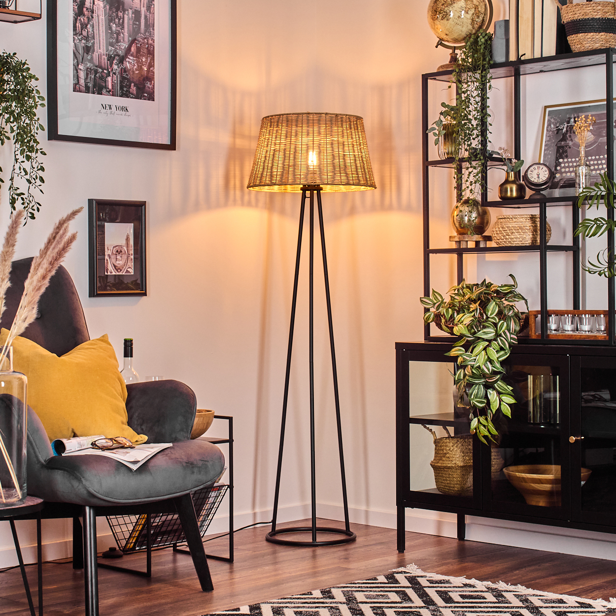 Innenraum mit Stehlampe, Stuhl und Dekoration, einschließlich gerahmter Kunst an der Wand.