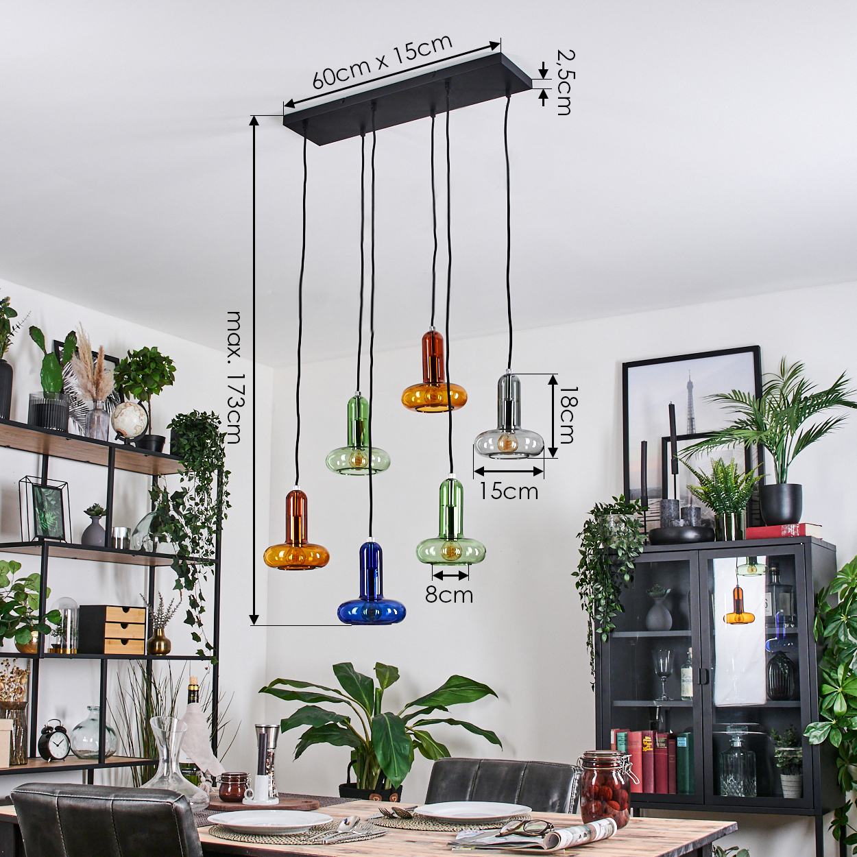 Esszimmer mit Hängelampen. Bunte Glasschirme hängen von der schwarzen Halterung.