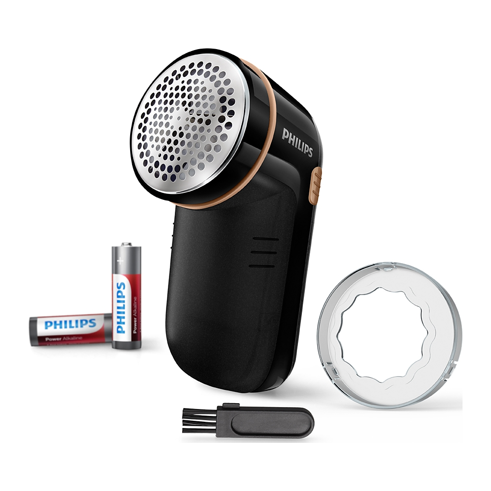 Black and gold lint remover with batteries and accessories on a white background.