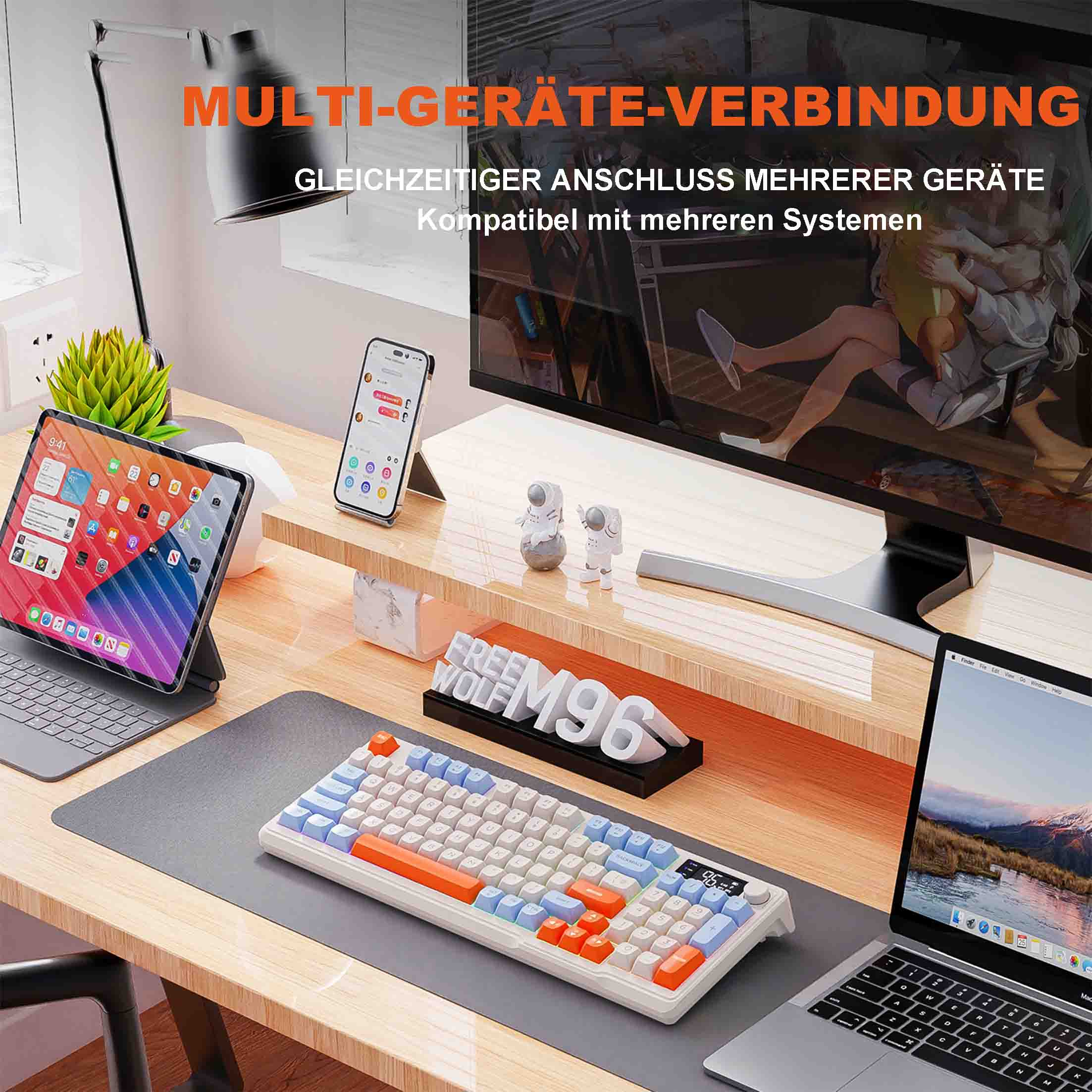 Miejsce pracy z wieloma urządzeniami, w tym klawiaturą, tabletem, monitorem i laptopem. Pomarańczowo-biała klawiatura.