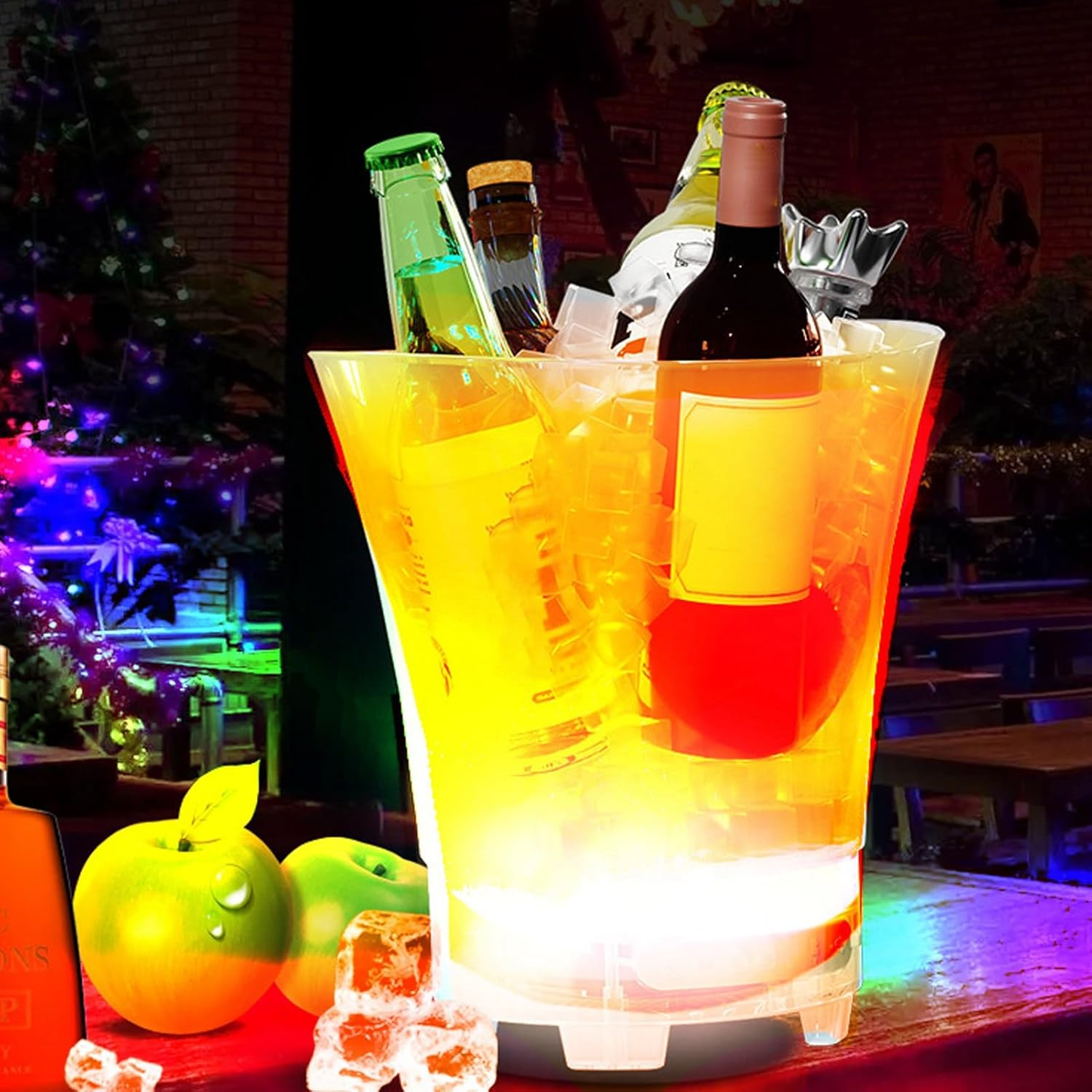 Cubo de hielo iluminado con bebidas y botellas, árbol de Navidad al fondo. Escena festiva.