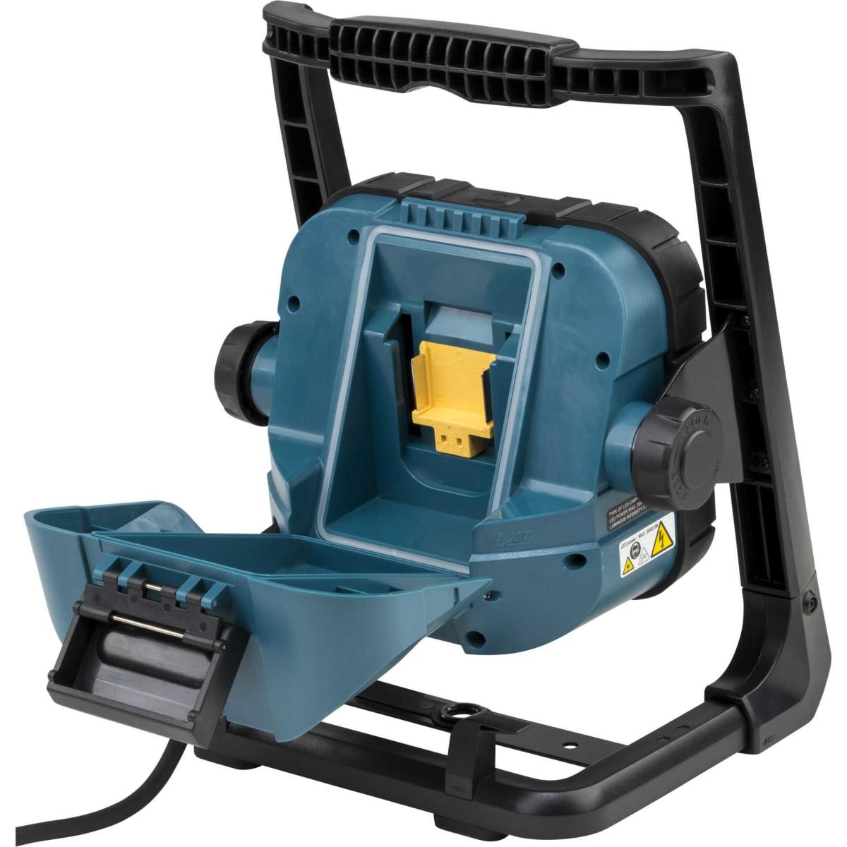 Luz de trabajo Makita turquesa y negra con compartimento abierto y asa negra.