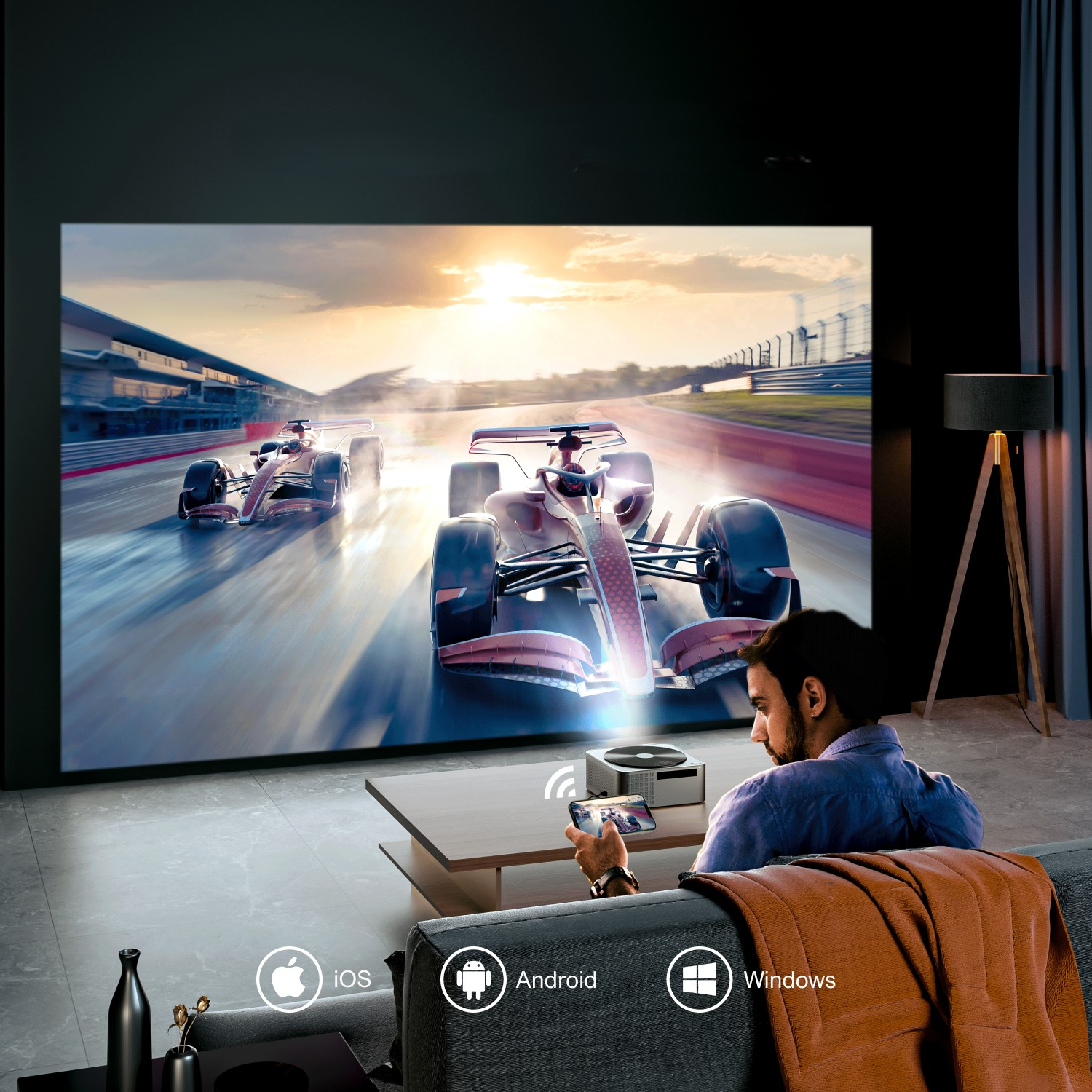Mężczyzna ogląda wyścig wyświetlany na ścianie. Projektor i telefon na stole. Ikony iOS, Android i Windows.