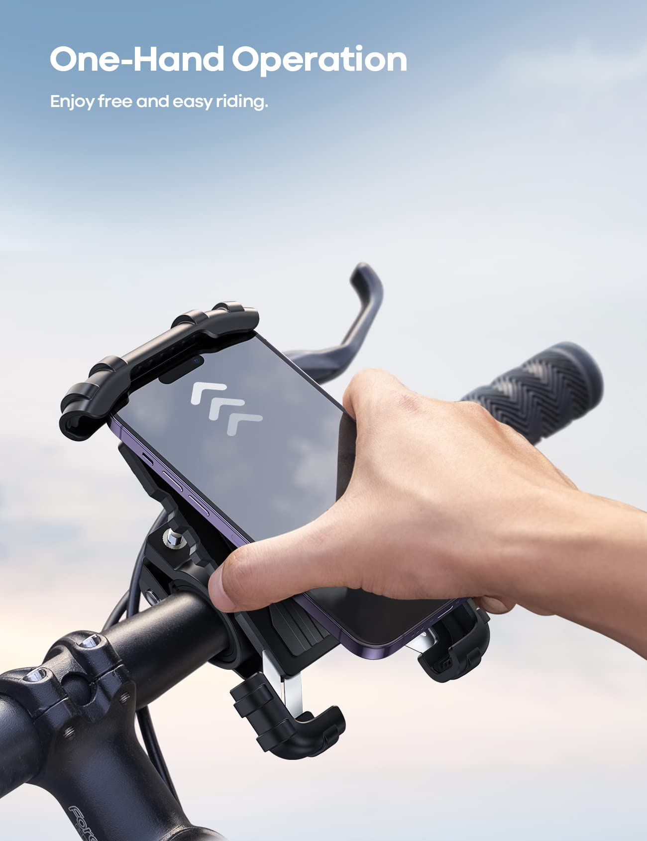 Hand legt Telefon in Motorrad-Lenkerhalterung. Das Motorrad ist dunkel, der Himmel hellblau.