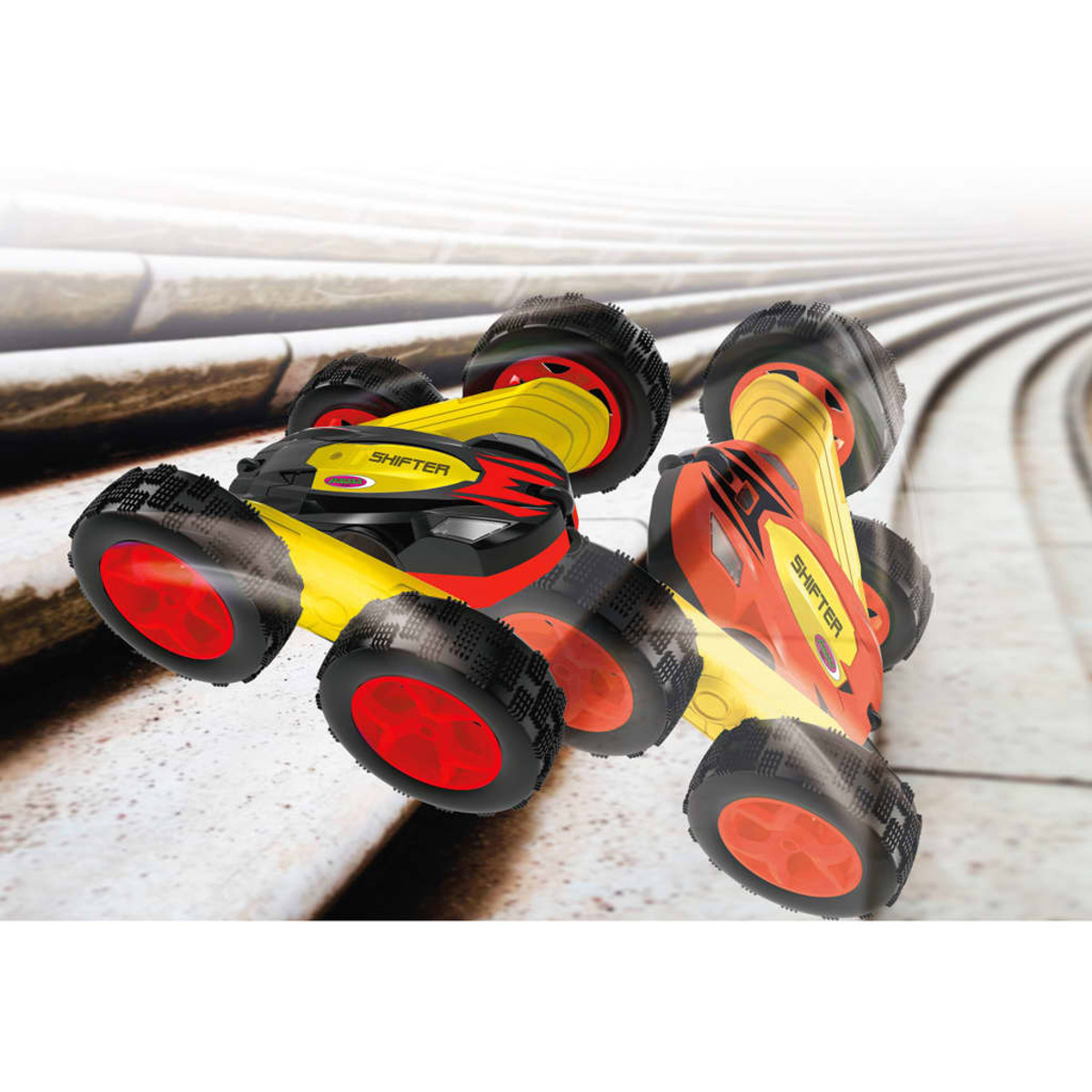 Zwei rot-gelbe Spielzeugautos mit schwarzen Reifen scheinen auf einer geschwungenen weißen Oberfläche zu fahren.