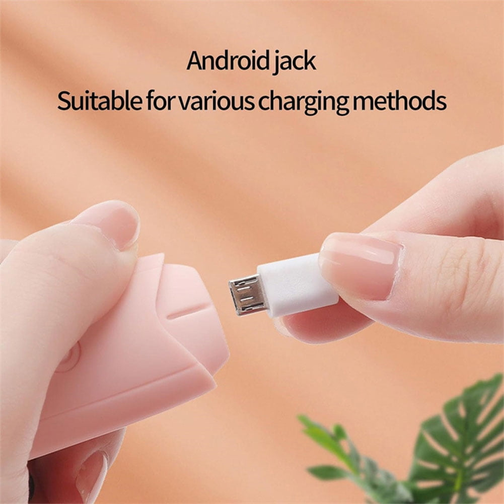 Hände verbinden weißes USB-Kabel mit rosa Gerät. Heller Hintergrund.