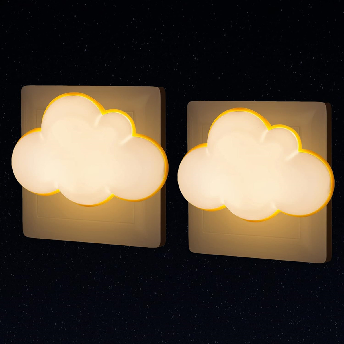 Zwei wolkenförmige, gelb beleuchtete Nachtlichter auf beigefarbenen Quadraten vor sternenklarem Hintergrund.