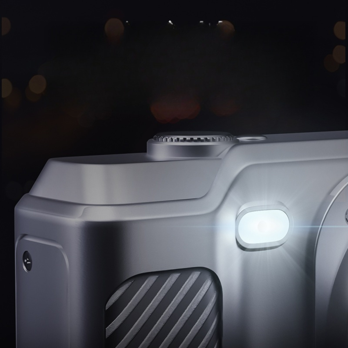 Zilveren camera met een flits, met een wazige achtergrond van lichten.