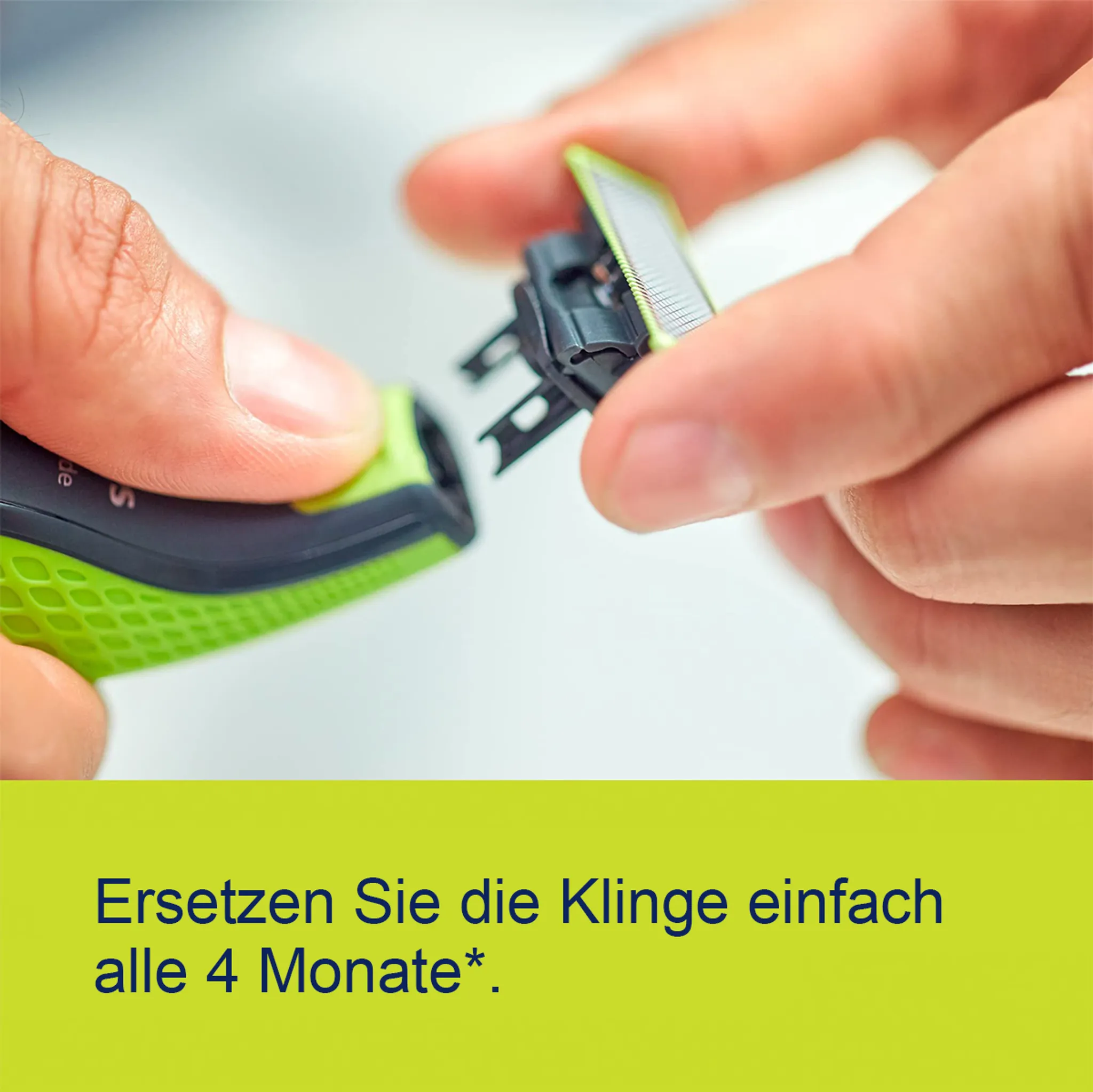 Zwei Hände entfernen einen grünen Rasiererkopf von einem schwarz-grünen Rasierer.