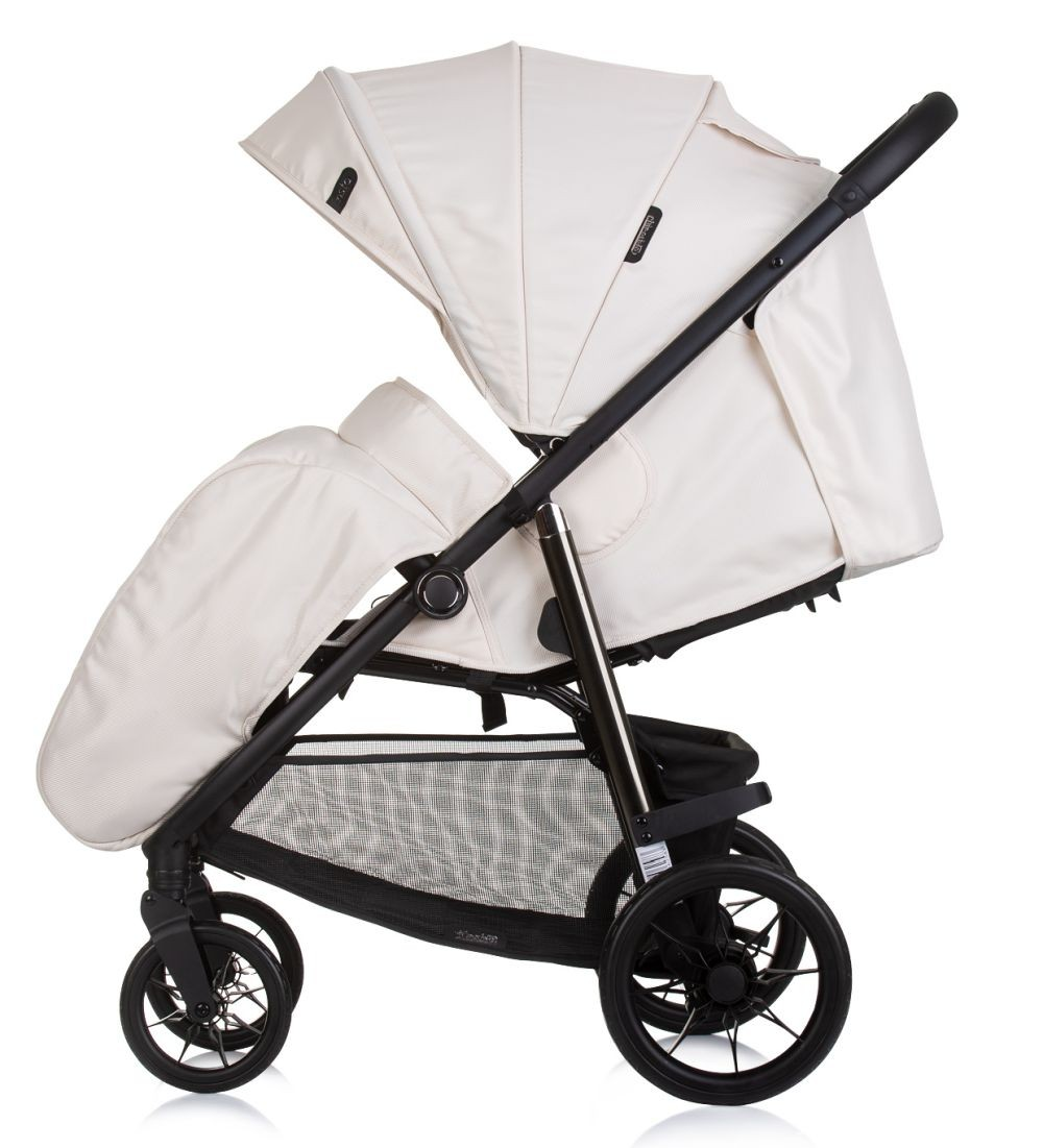 Cremefarbener Kinderwagen, Seitenansicht, mit zwei Sitzen, schwarzem Rahmen und Rädern.