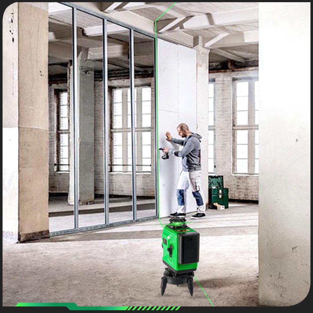Mann benutzt grünen Laser in Raum mit Trockenbau. Grüne Linien an der Wand.