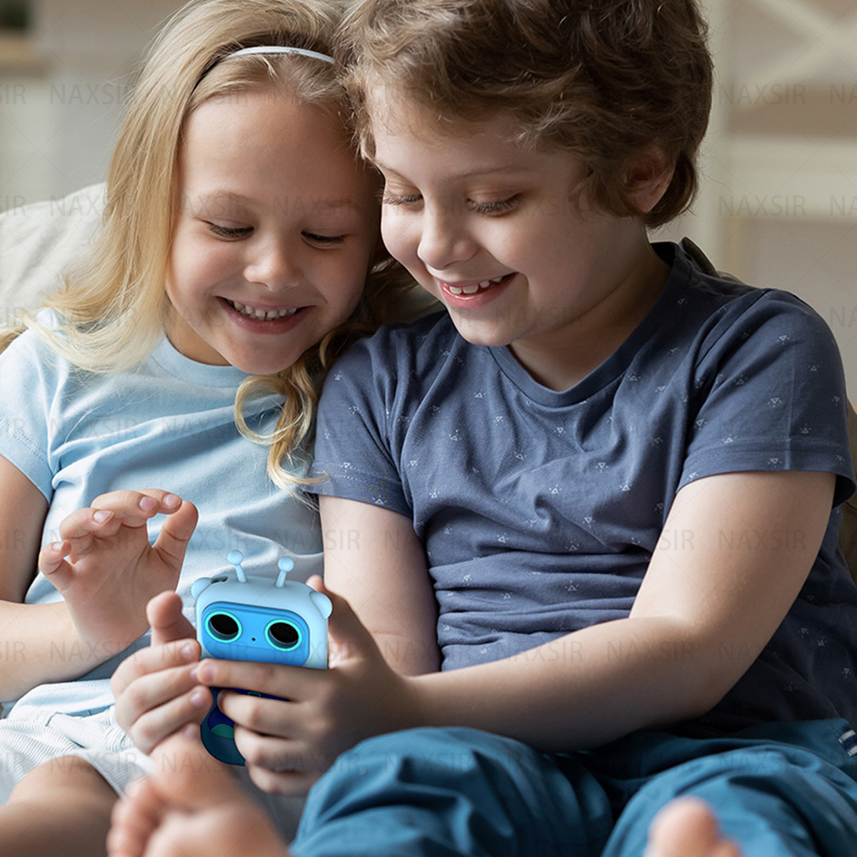Due bambini guardano un giocattolo robot blu con antenne.