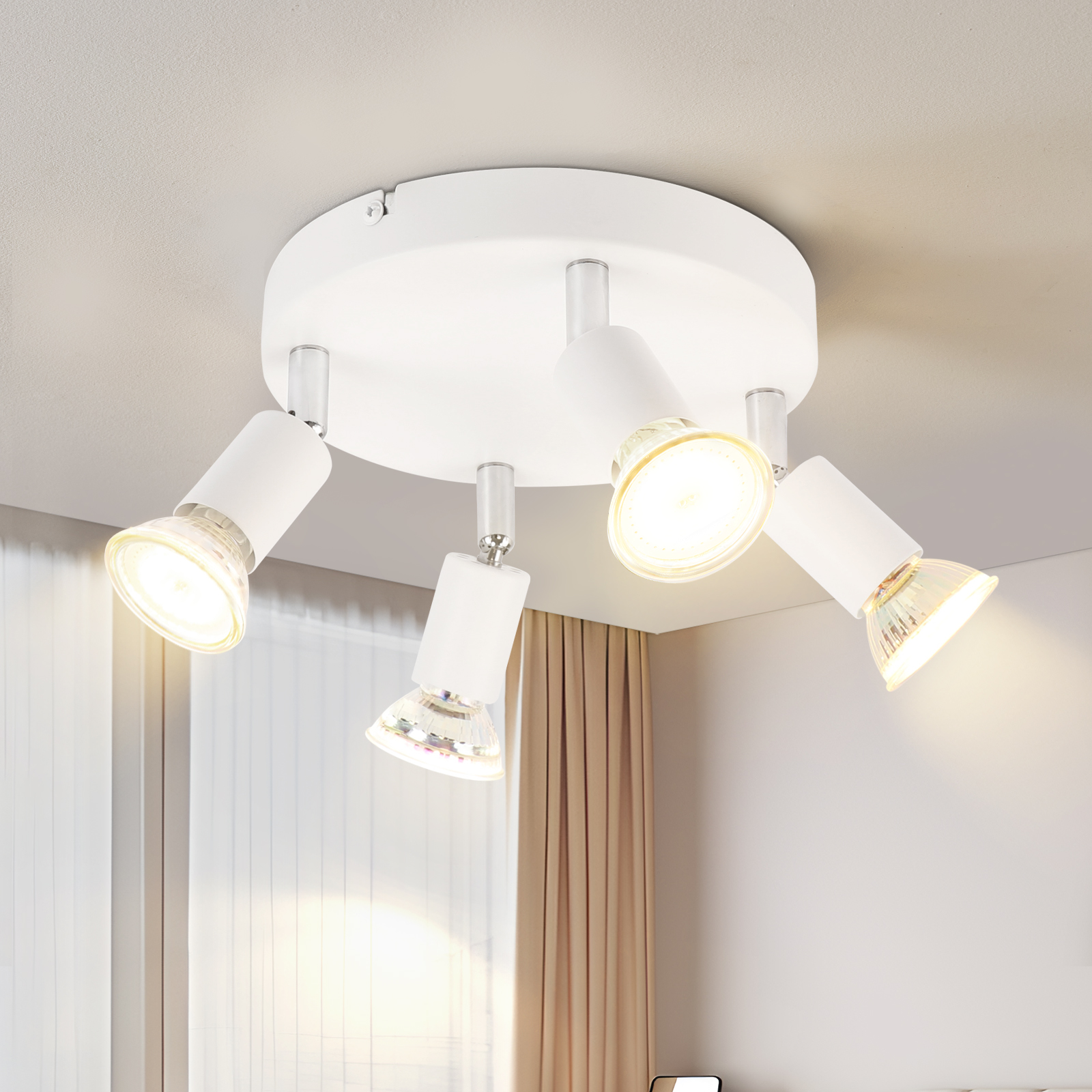 Lampada da soffitto bianca con quattro luci regolabili. Le luci sono angolate verso il basso.