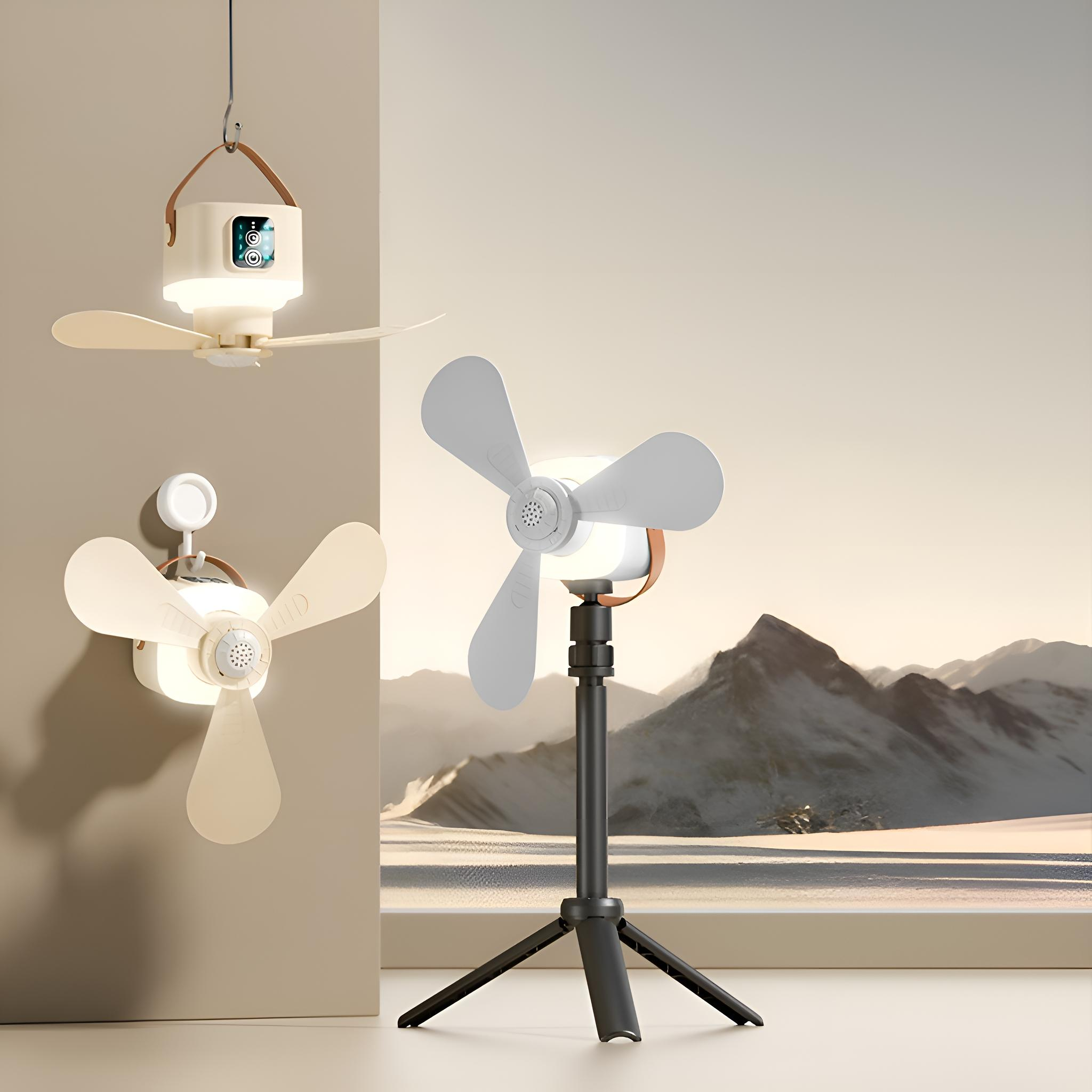 Drei Ventilatoren, einer hängend, einer an der Wand, einer auf einem Stativ, in der Nähe von Bergen.