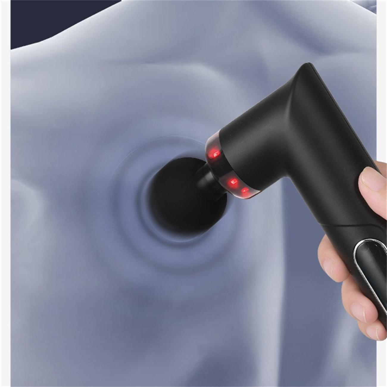 Schwarze Massagepistole auf Schulter, rote Lichter am Gerät.