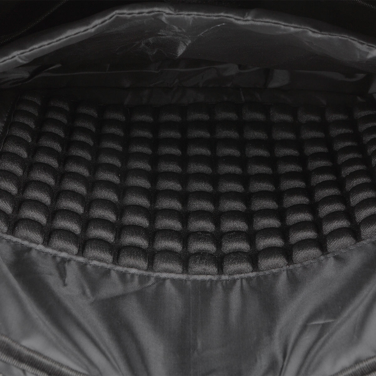 Wnętrze czarnej torby z wyściełaną podszewką o wzorze plastra miodu.