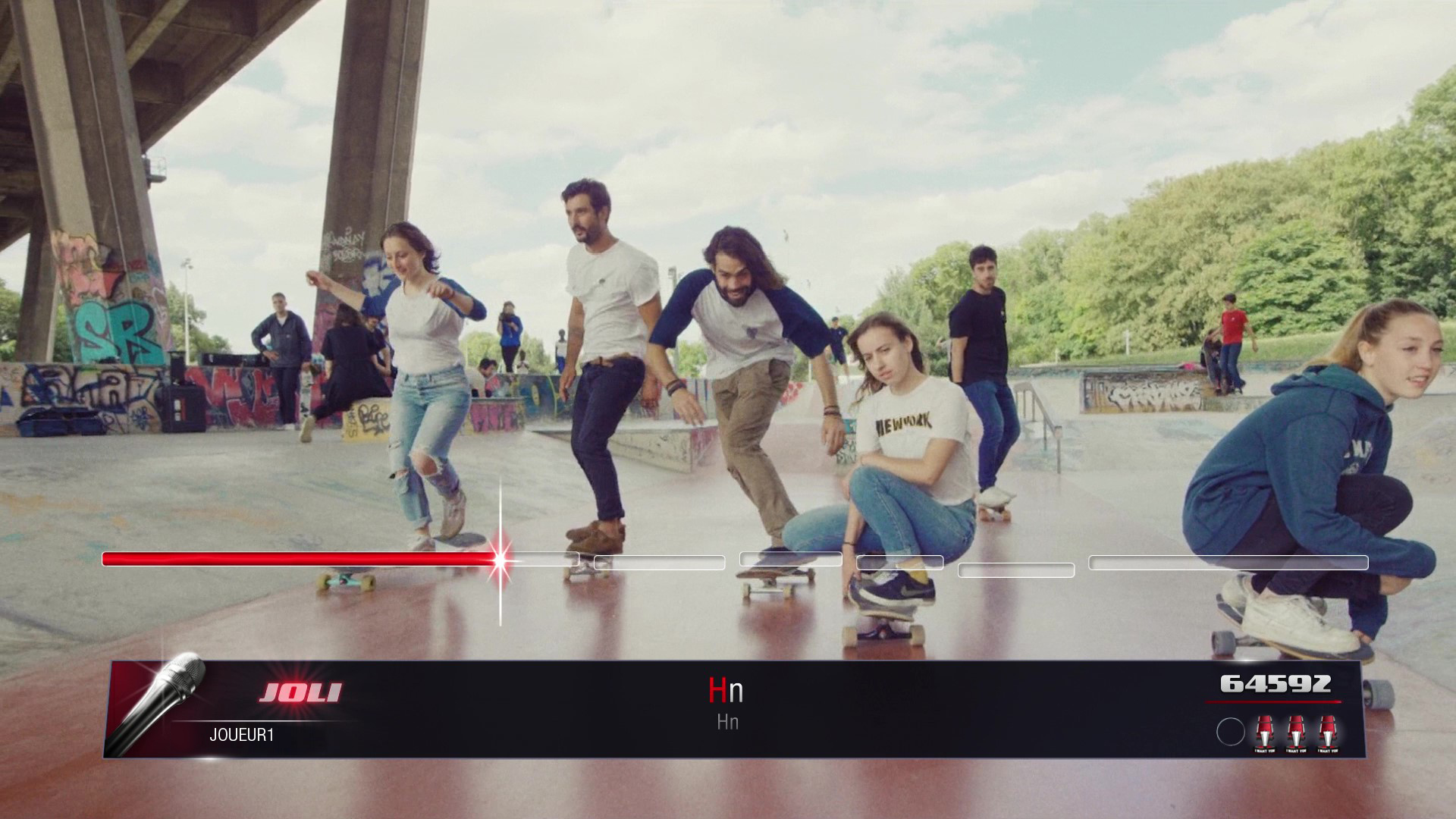 Grupa osób jeżdżących na deskorolce w betonowym skateparku. Interfejs gry widoczny na dole.