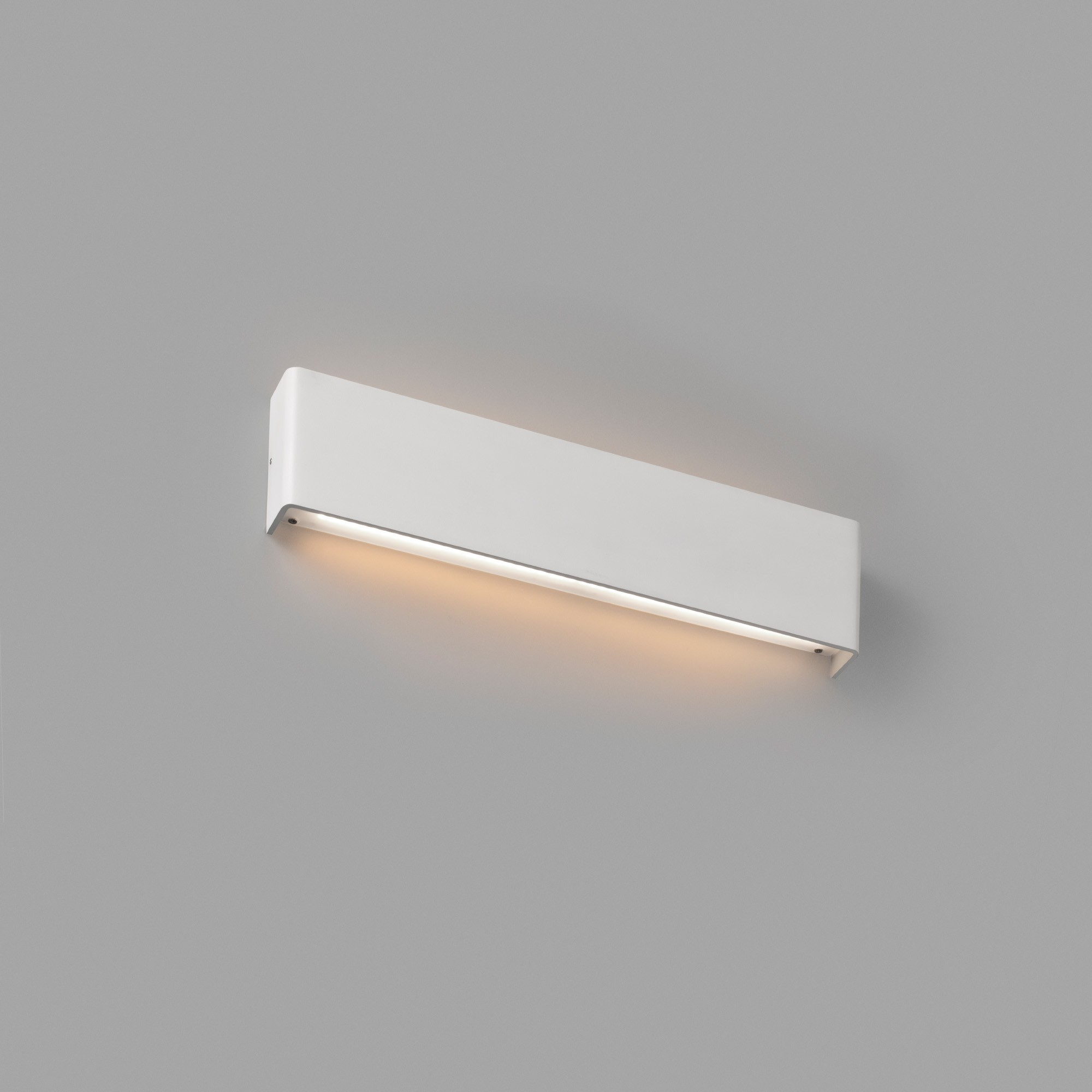 Un apparecchio di illuminazione rettangolare bianco montato su un muro grigio. La luce è accesa.