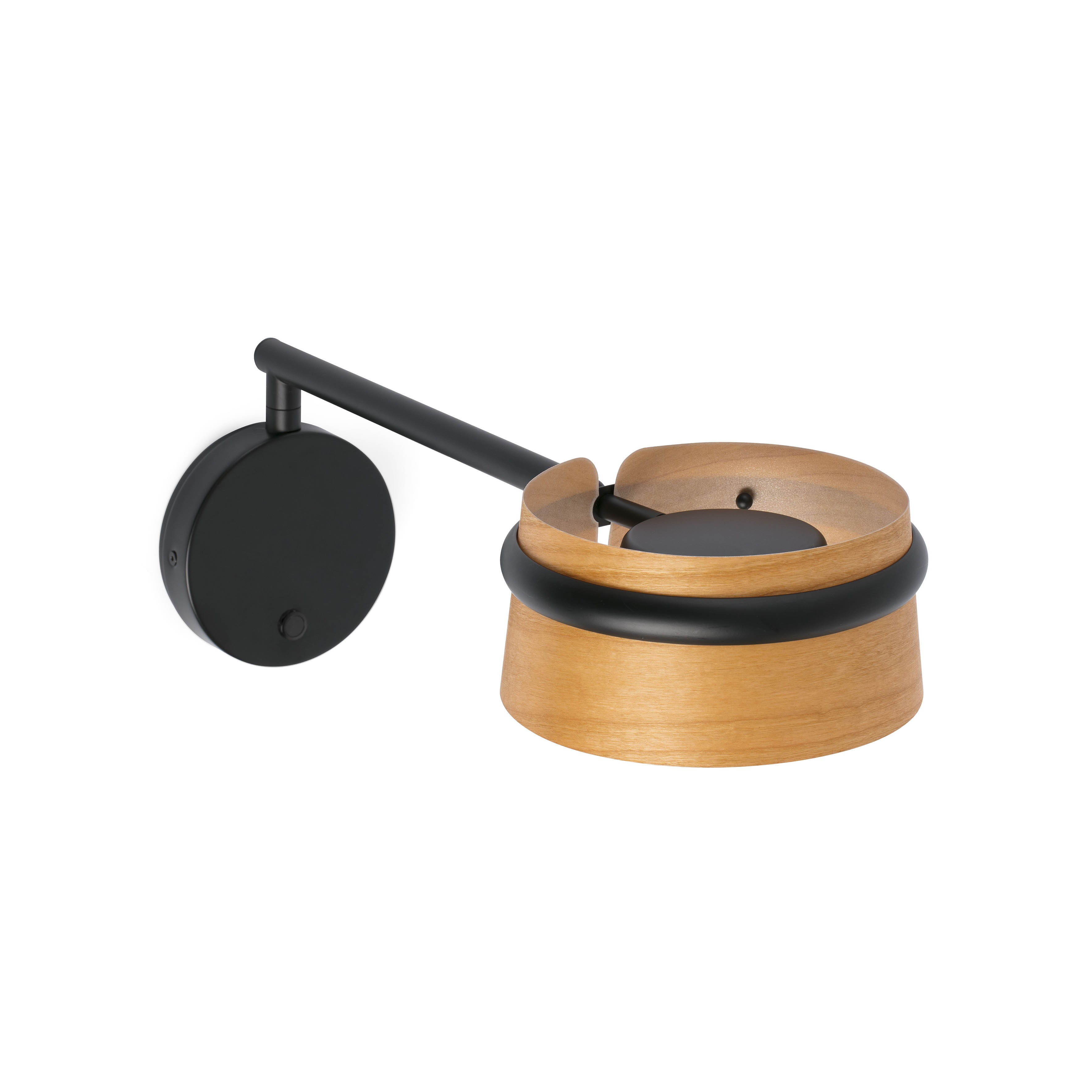 Lampada da parete nera e in legno. È montata su una parete bianca.