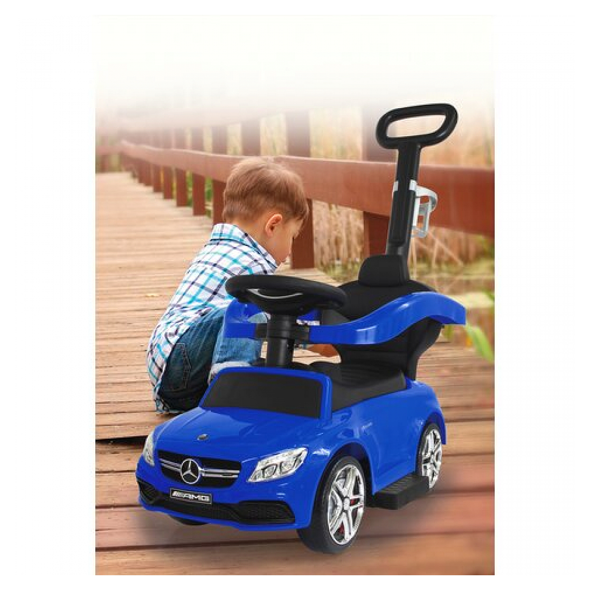Un'auto giocattolo Mercedes-Benz blu con un bambino e sfondo in legno.