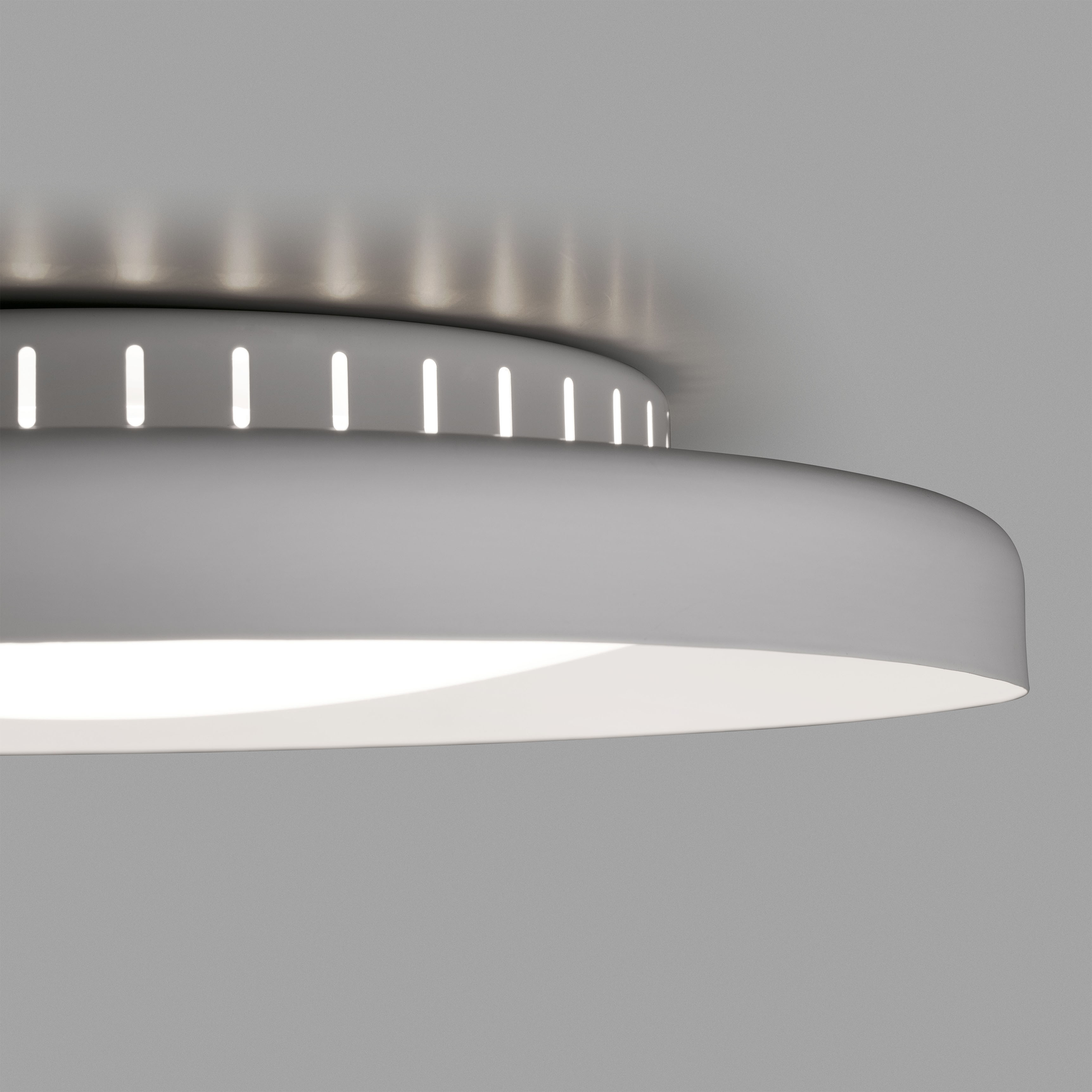 Una moderna plafoniera, grigia, con forma rotonda e luce brillante.
