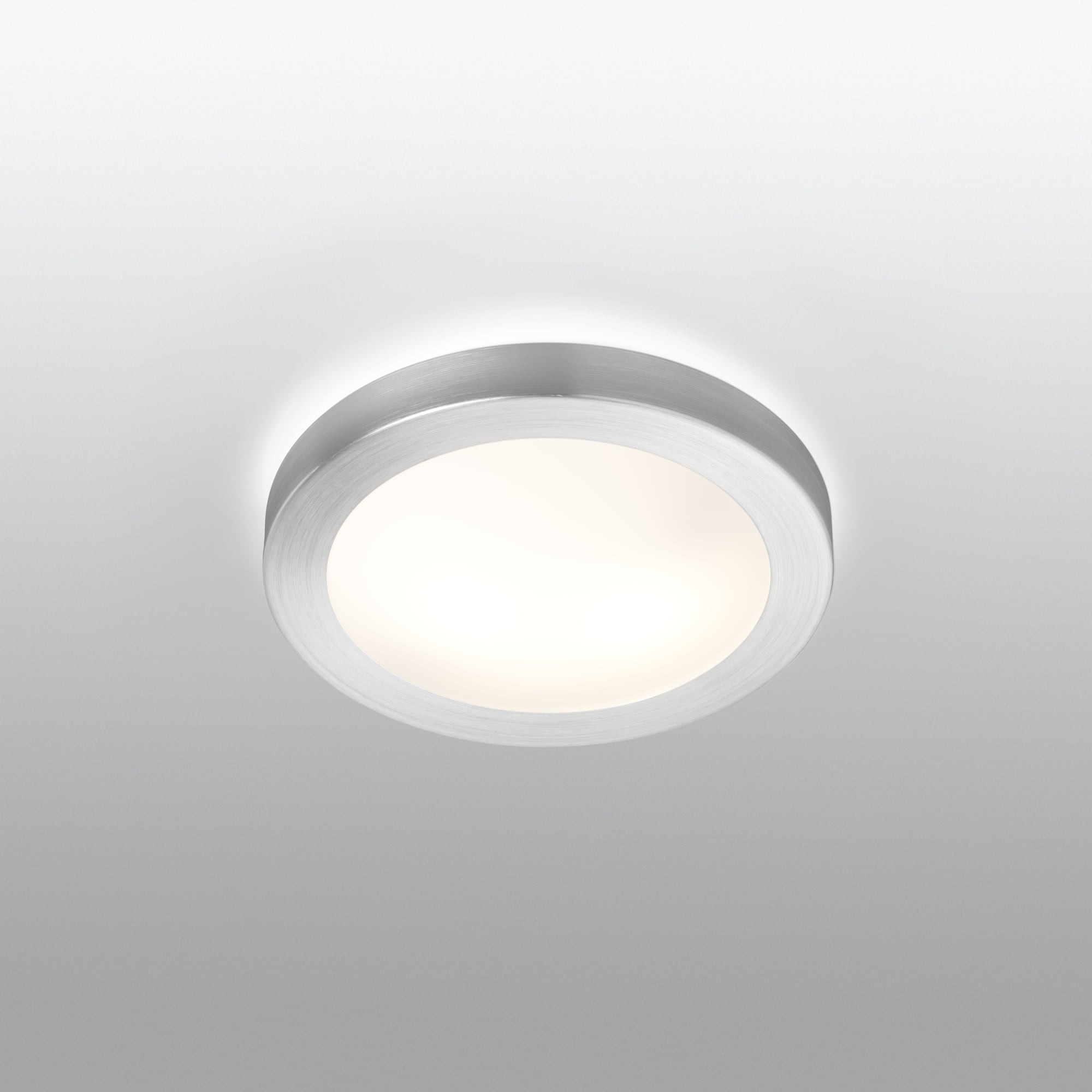 Una plafoniera rotonda argentata con un centro bianco brillante.