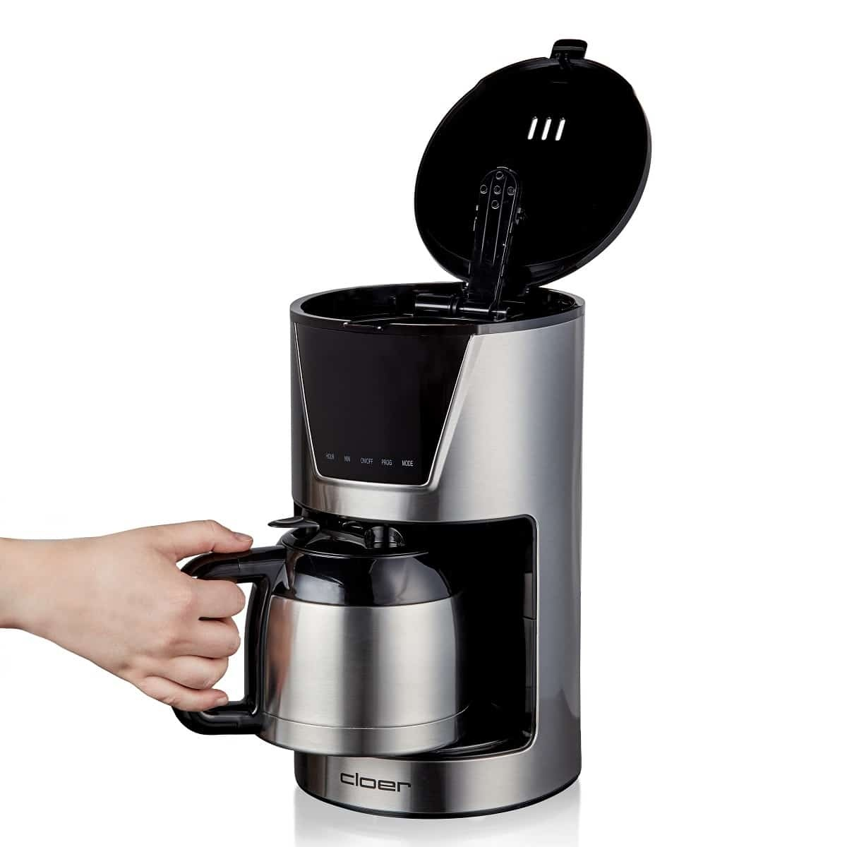 Srebrno-czarny ekspres do kawy z ręką osoby trzymającej karafkę.