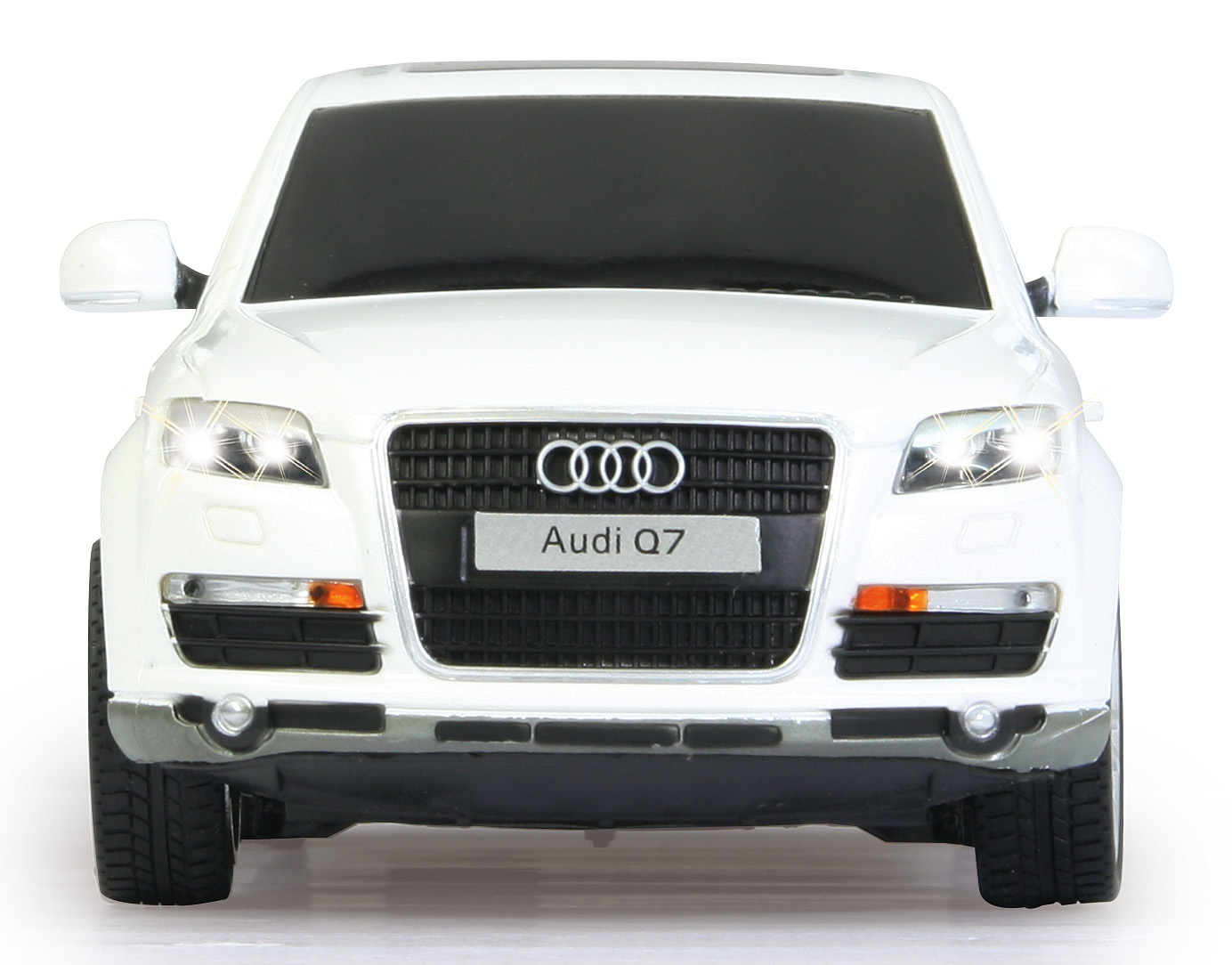 Biały samochód Audi Q7 z przodu. Włączone reflektory. Czarny grill z logo Audi. Białe tło.