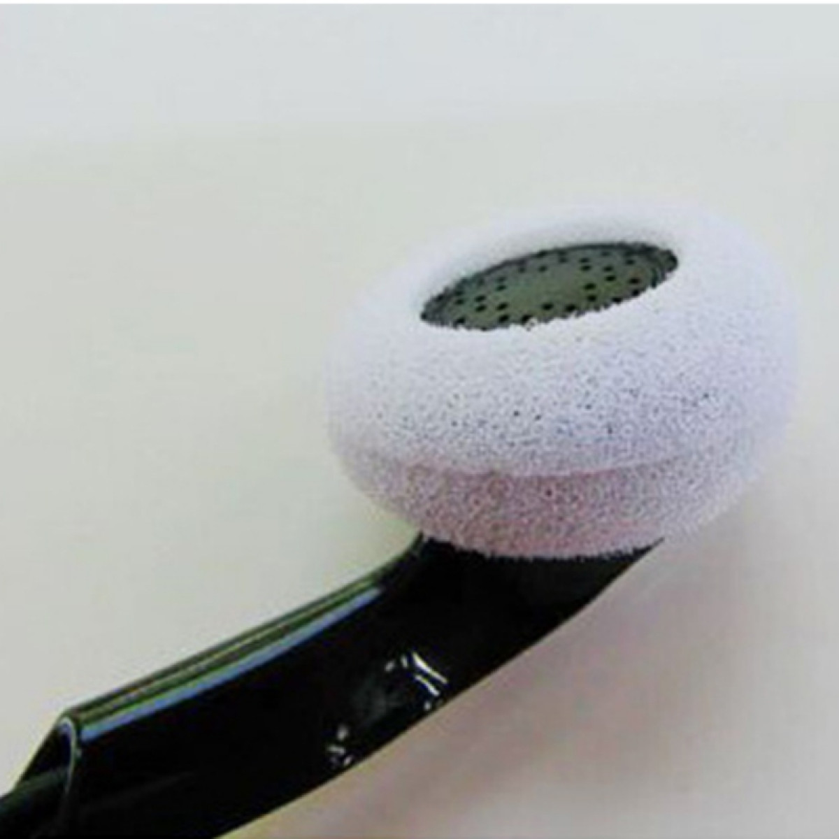 Zbliżenie białej piankowej osłony słuchawki na czarnej słuchawce.