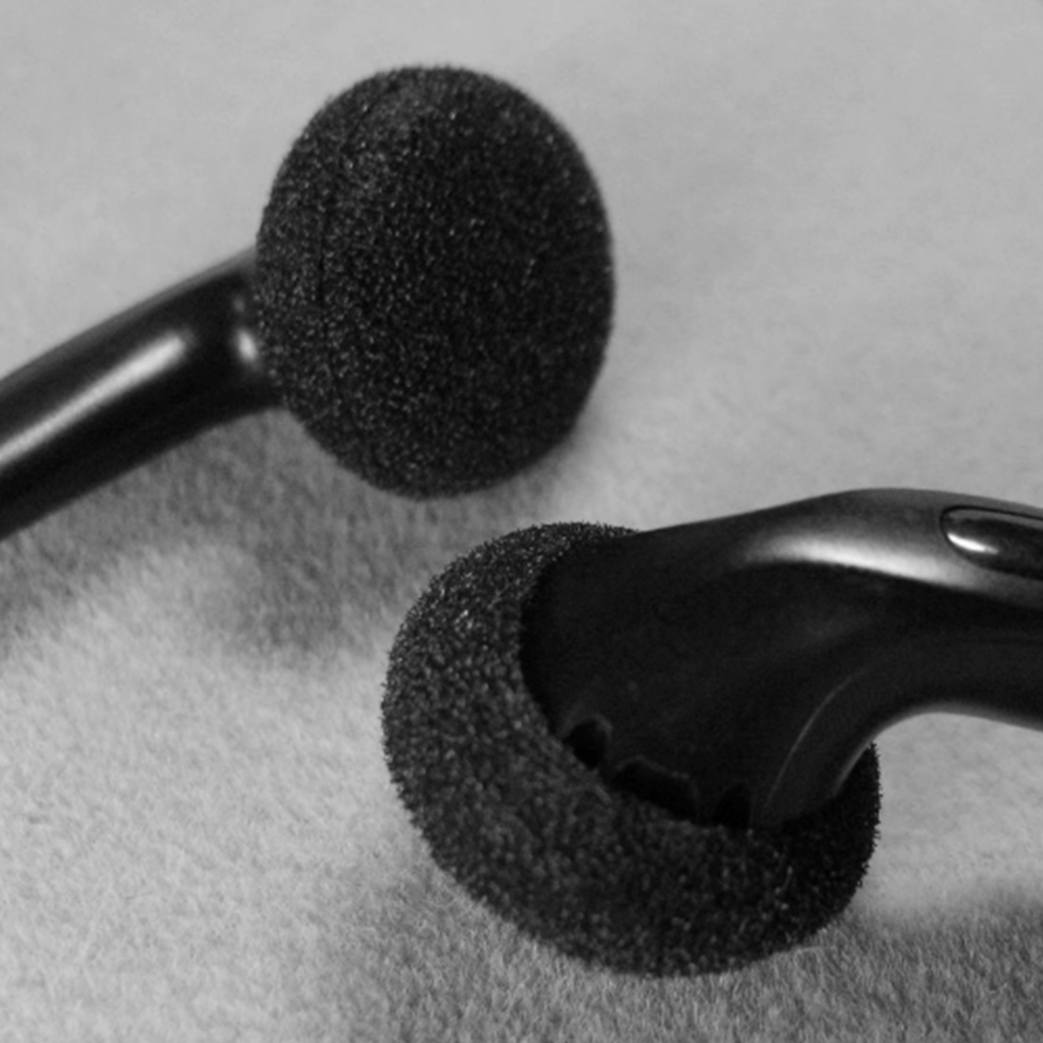 Zbliżenie czarnych słuchawek z czarnymi piankowymi osłonami.