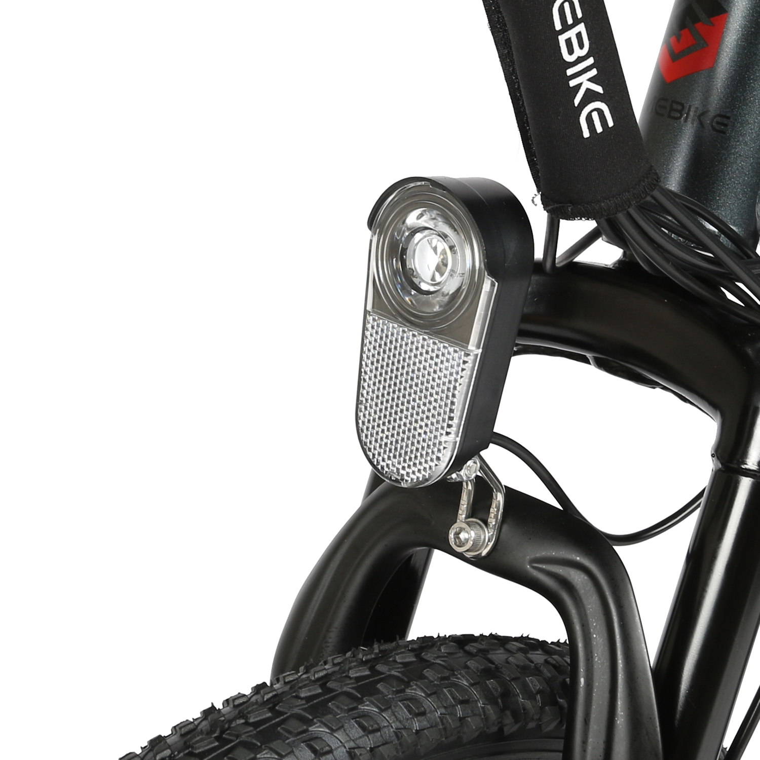 Zbliżenie przedniego światła roweru elektrycznego. Widoczny również widelec przedni i opona.