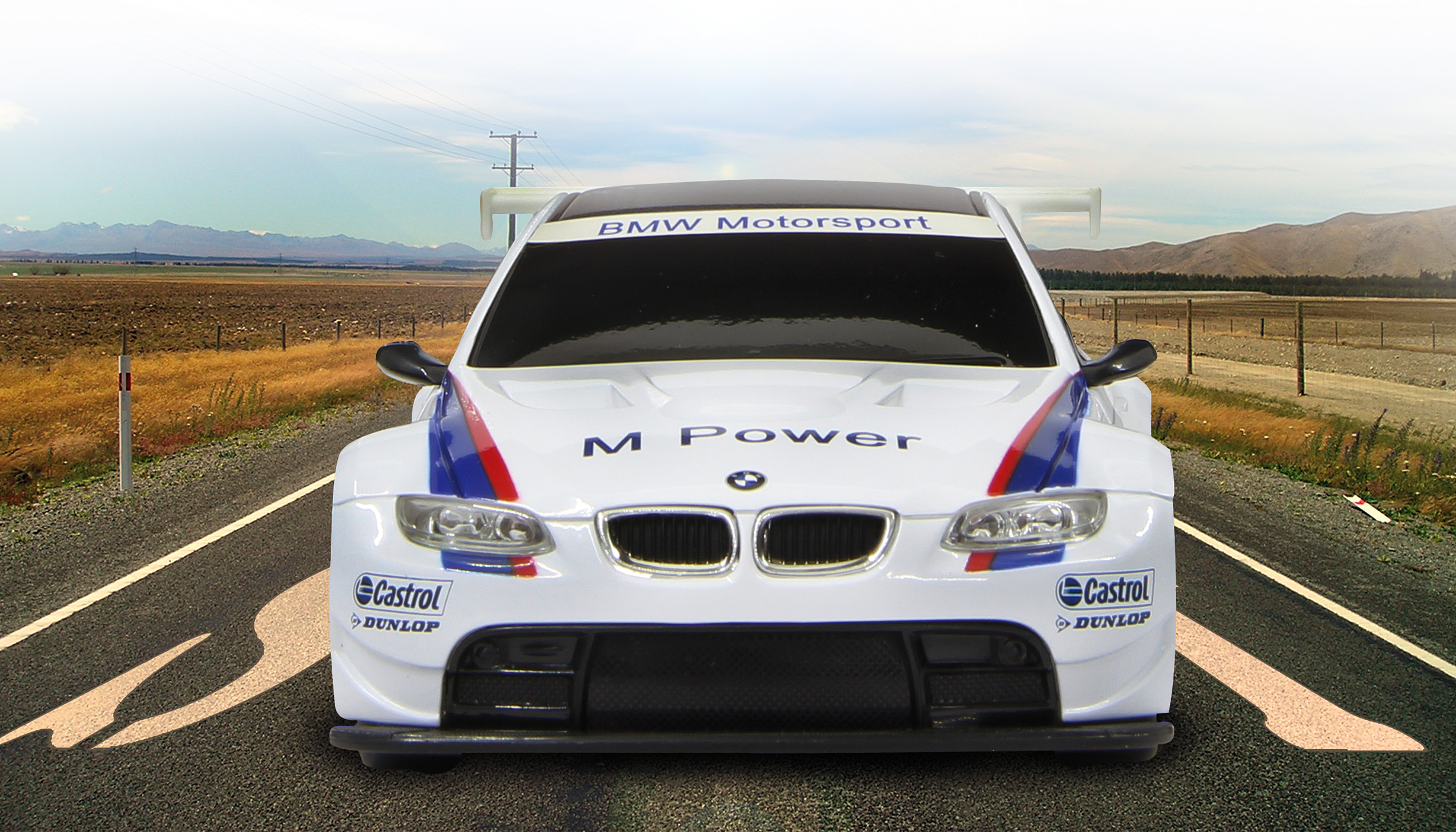 Biało-niebieski samochód wyścigowy na drodze, góry w tle.