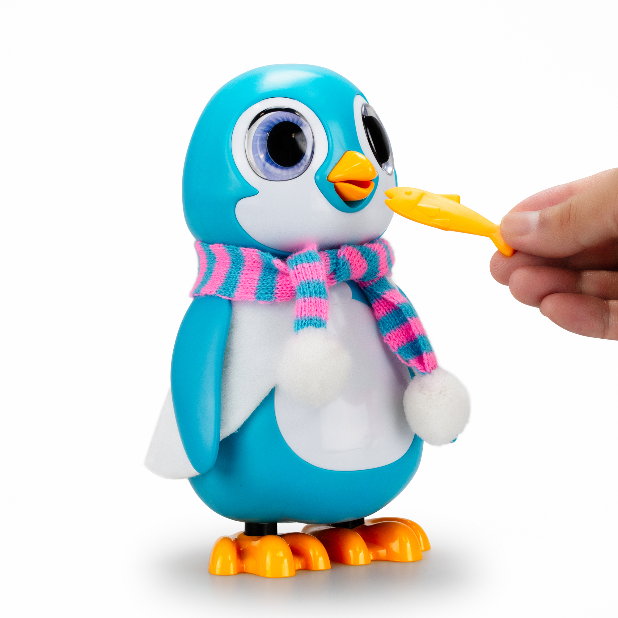 Un pinguino giocattolo viene nutrito con un pesce giallo da una mano su sfondo bianco.