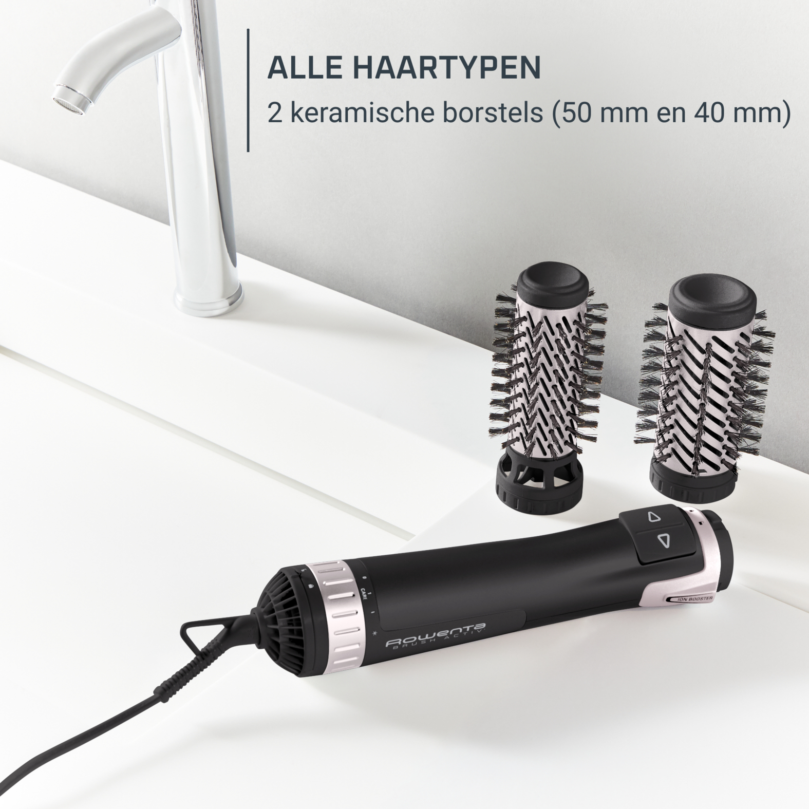 Strumenti per lo styling dei capelli su una superficie bianca. Un asciugacapelli e due spazzole in ceramica.