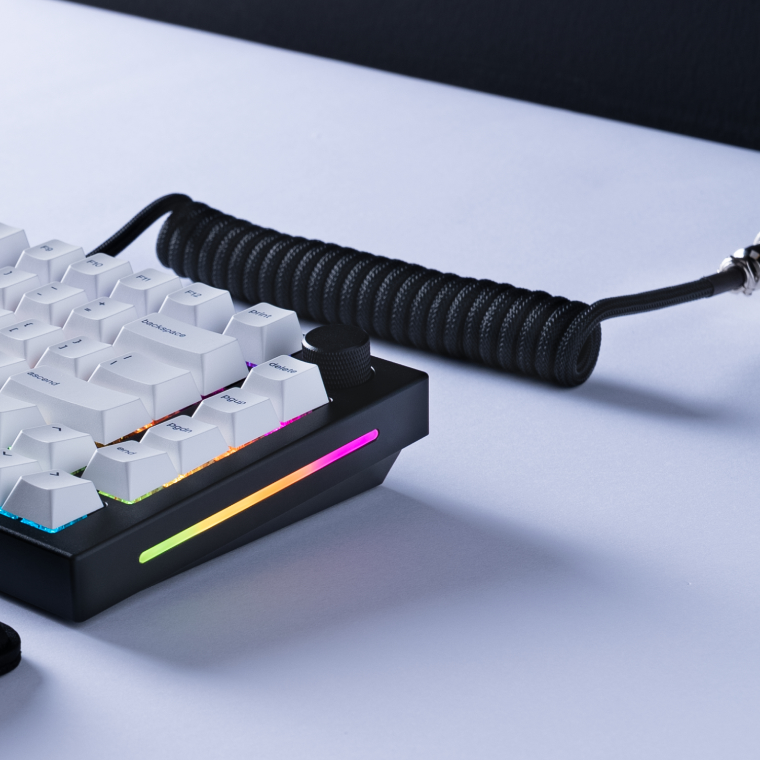 Tastiera bianca e nera con tasti bianchi e cavo a spirale nero. Illuminazione RGB.