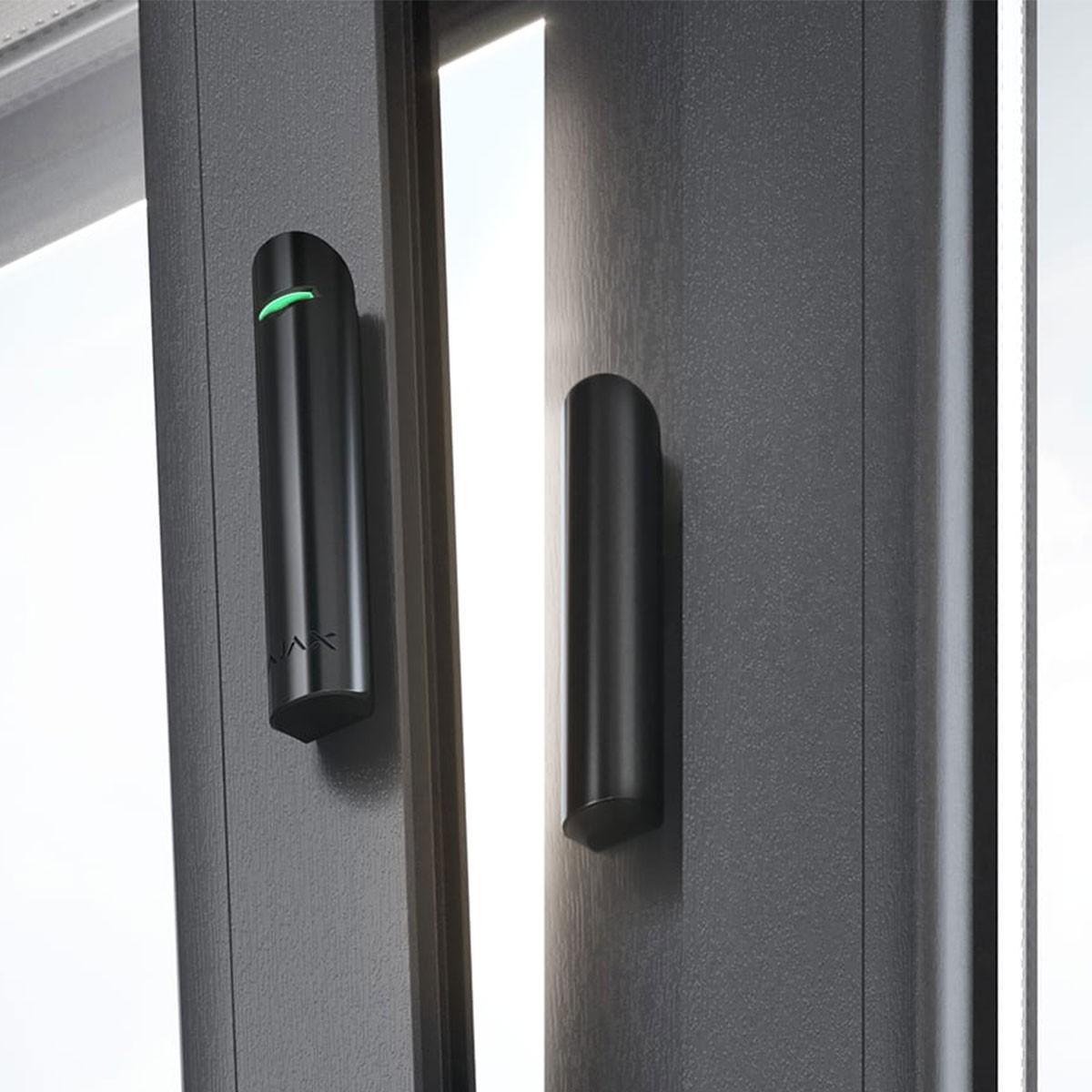 Sensor de seguridad negro en un marco de ventana. Luz verde encendida. Otro sensor al lado.