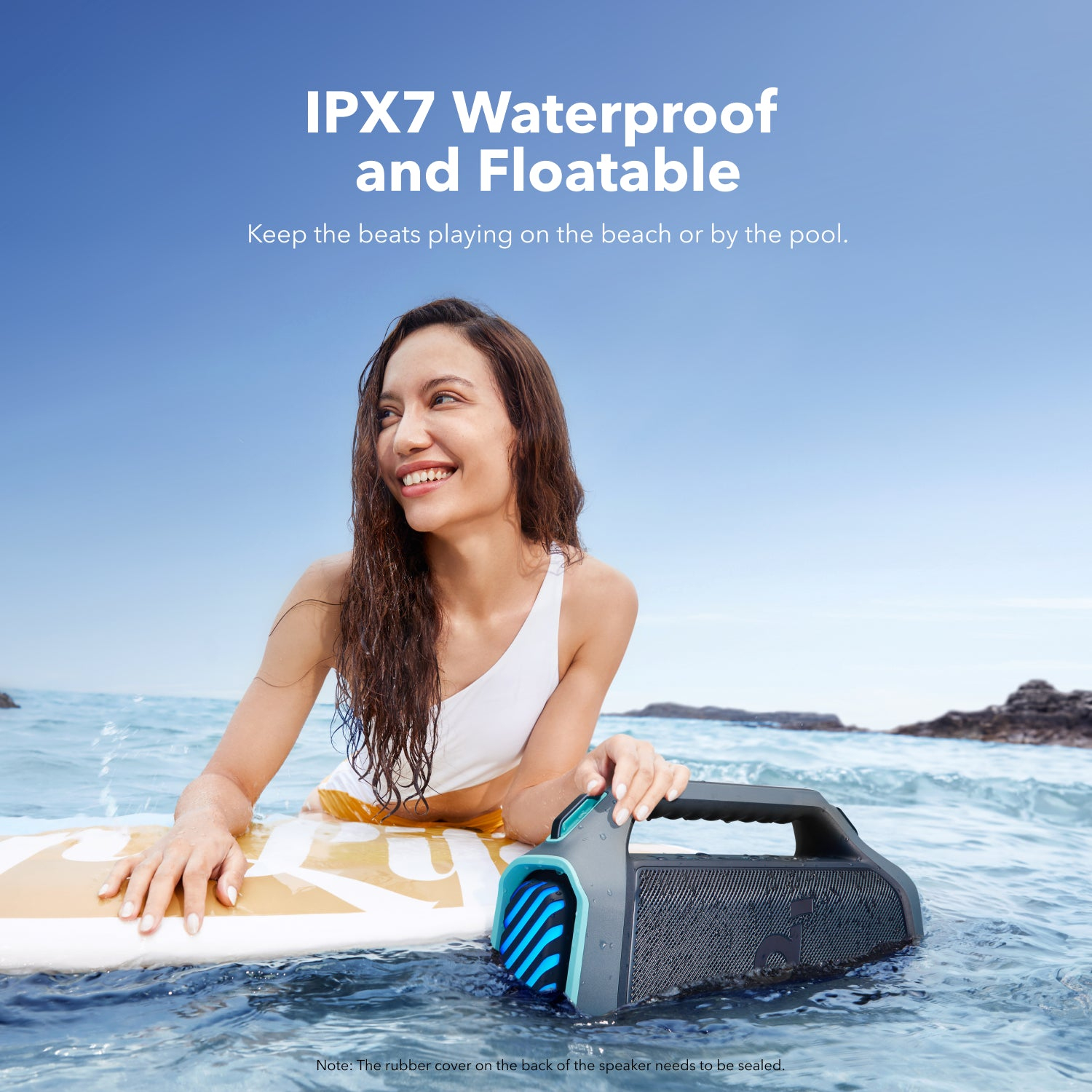 Kobieta na desce surfingowej w wodzie, trzymająca głośnik przenośny, obraz oznaczony 'IPX7 Waterproof'.