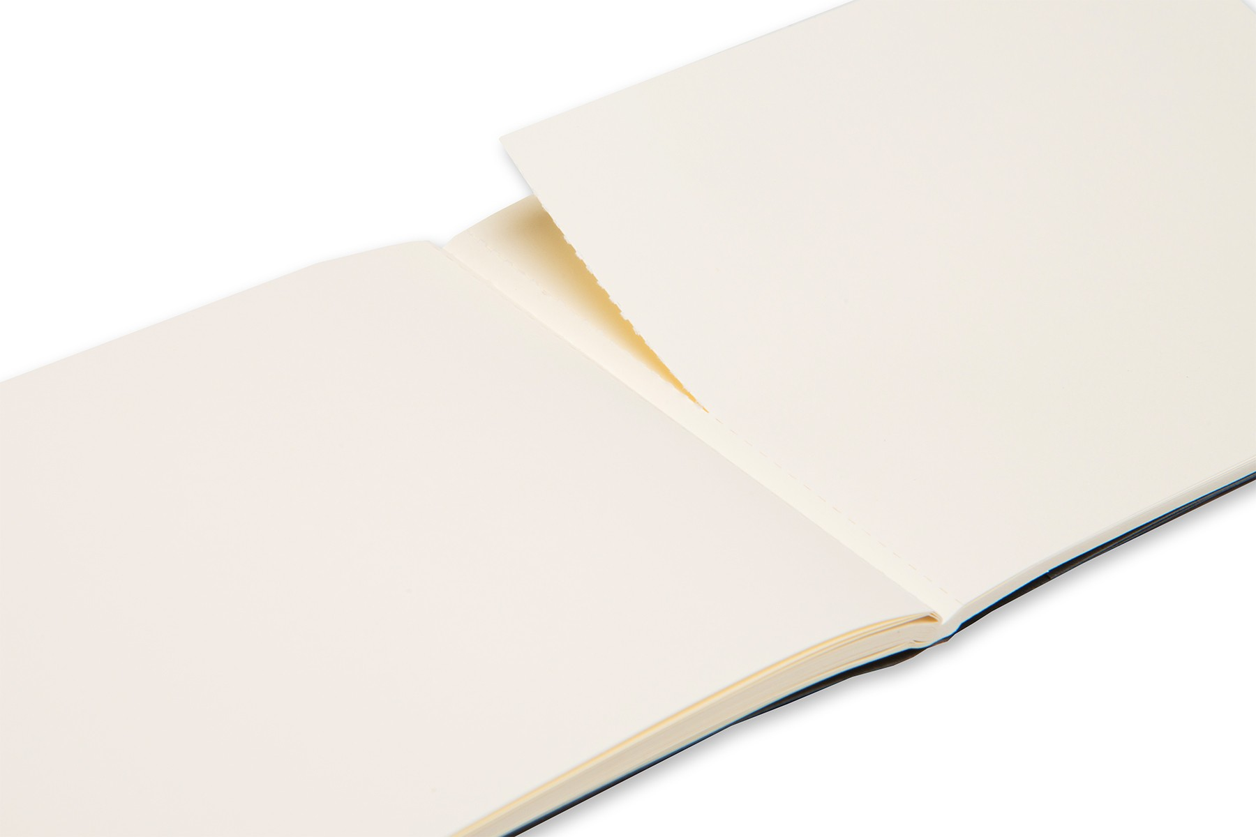 Otwarty szkicownik Moleskine na białej powierzchni, odsłaniający puste strony.