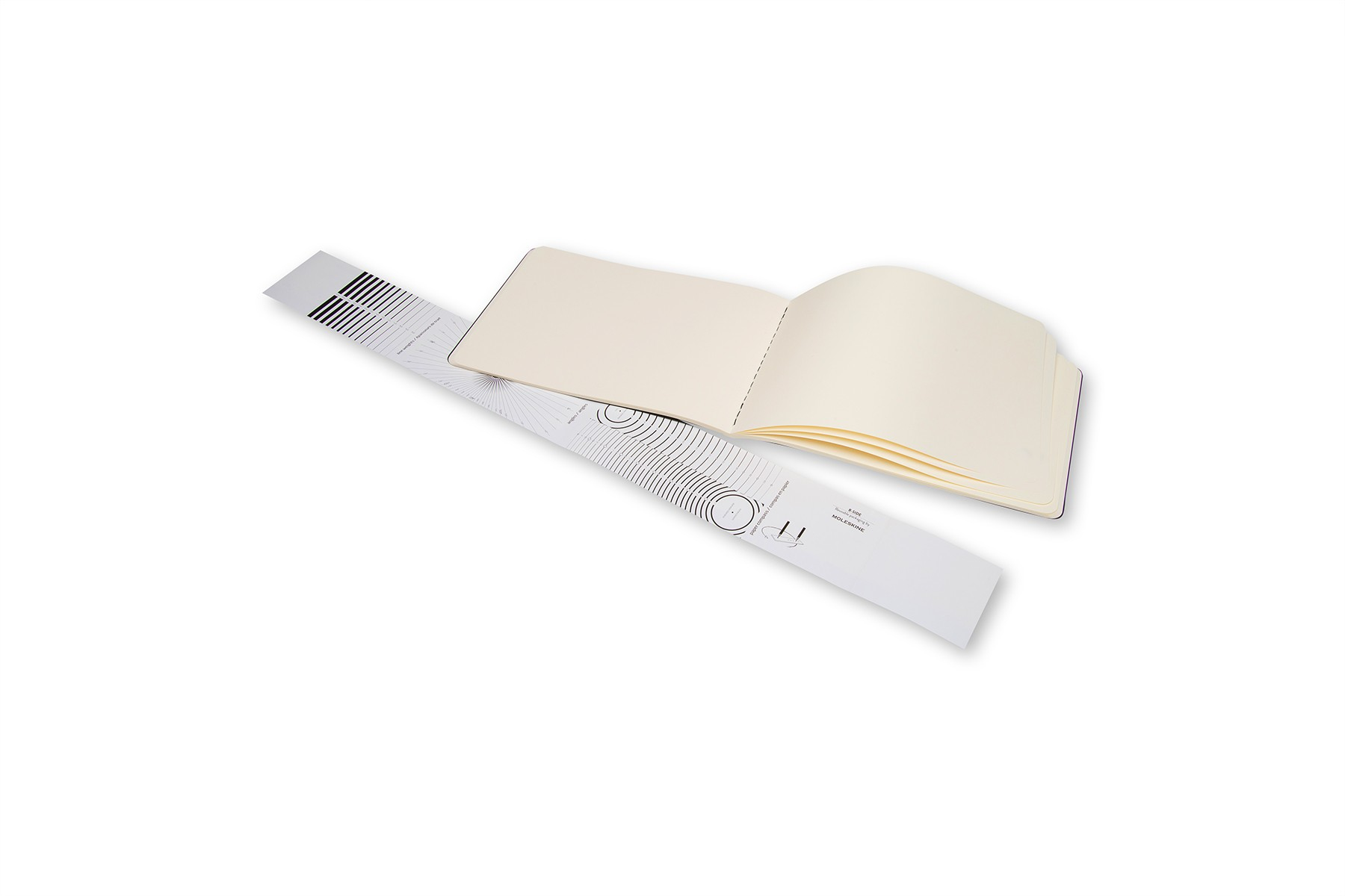 Otwarty notatnik z pustymi stronami i linijką. Linijka jest pod kątem.