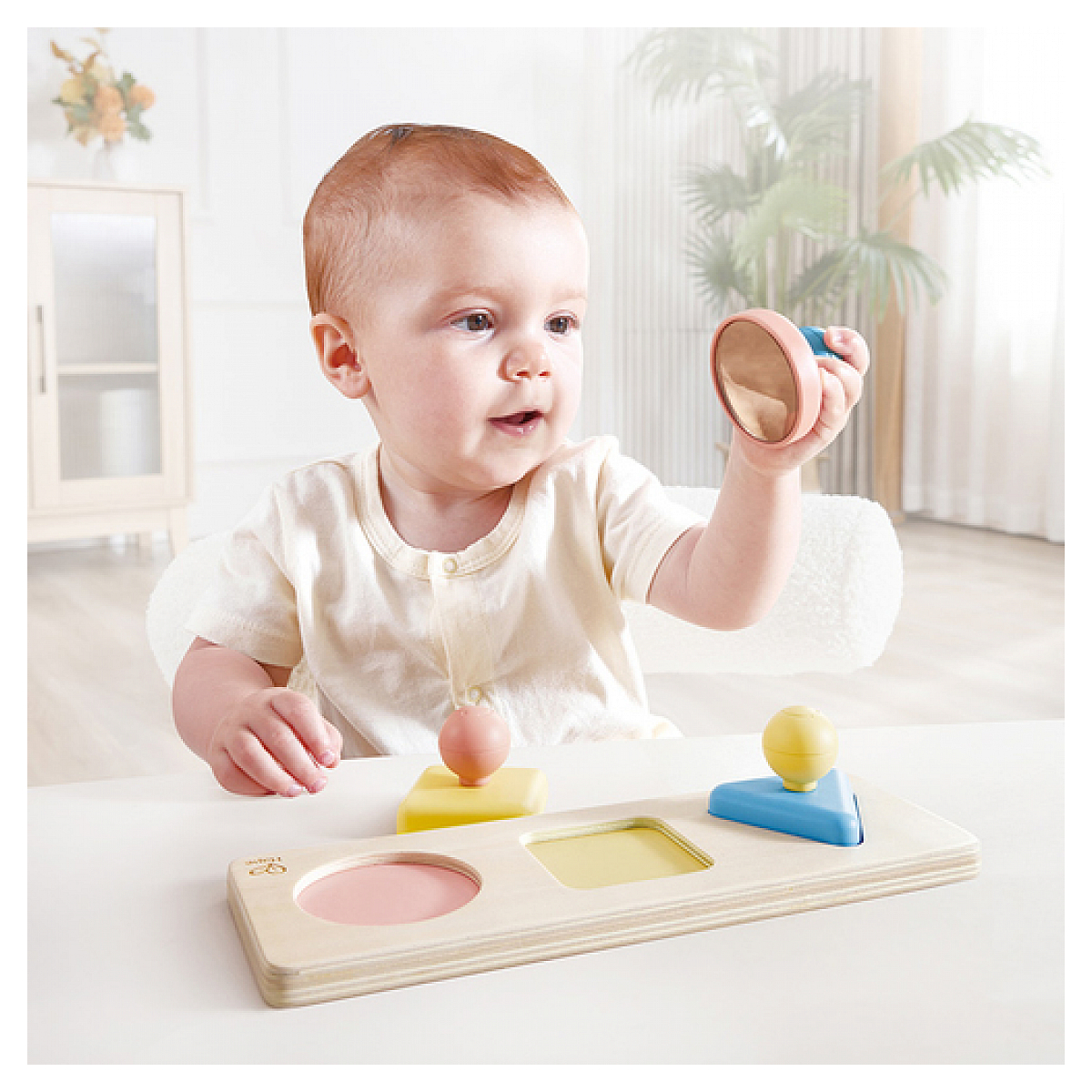 Dziecko z zabawką logiczną z kształtami i kolorami.