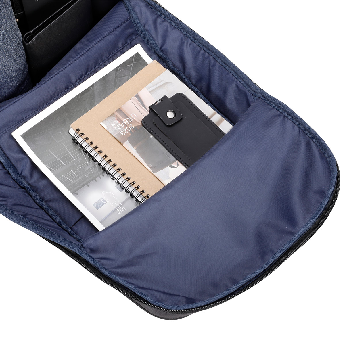 Otwarty plecak z notatnikami i czarnym portfelem. Pióro jest widoczne w kieszeni.