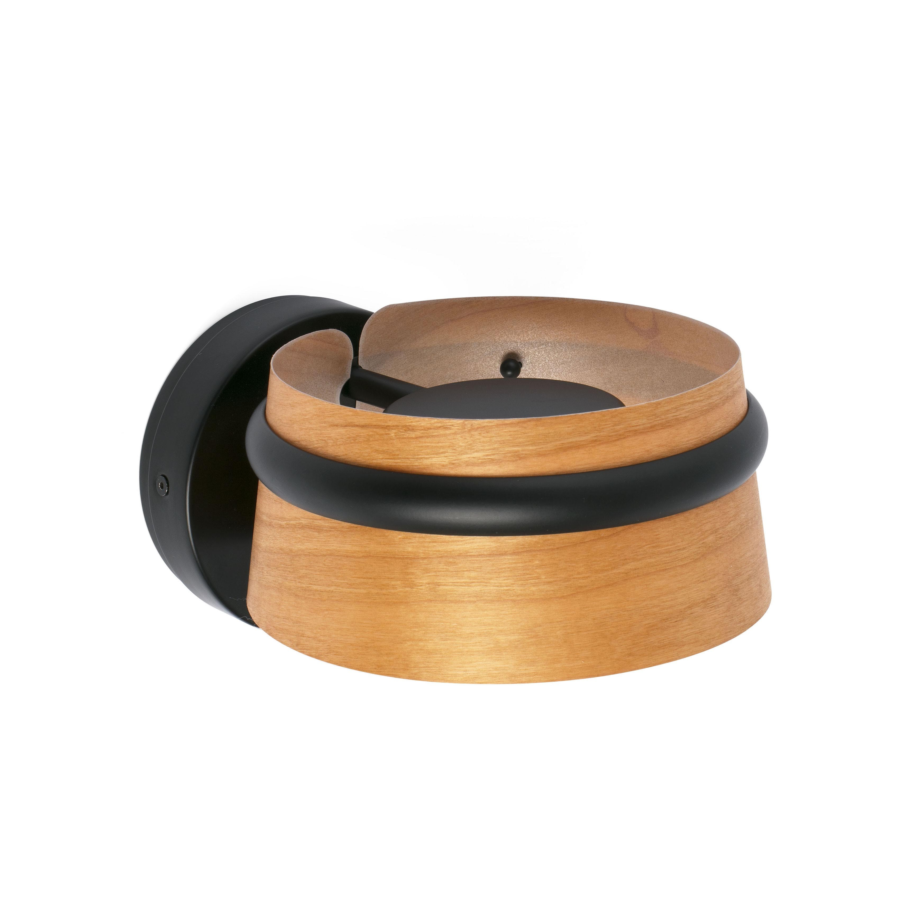 Lampada rotonda in legno con anello nero, montata su base circolare nera.